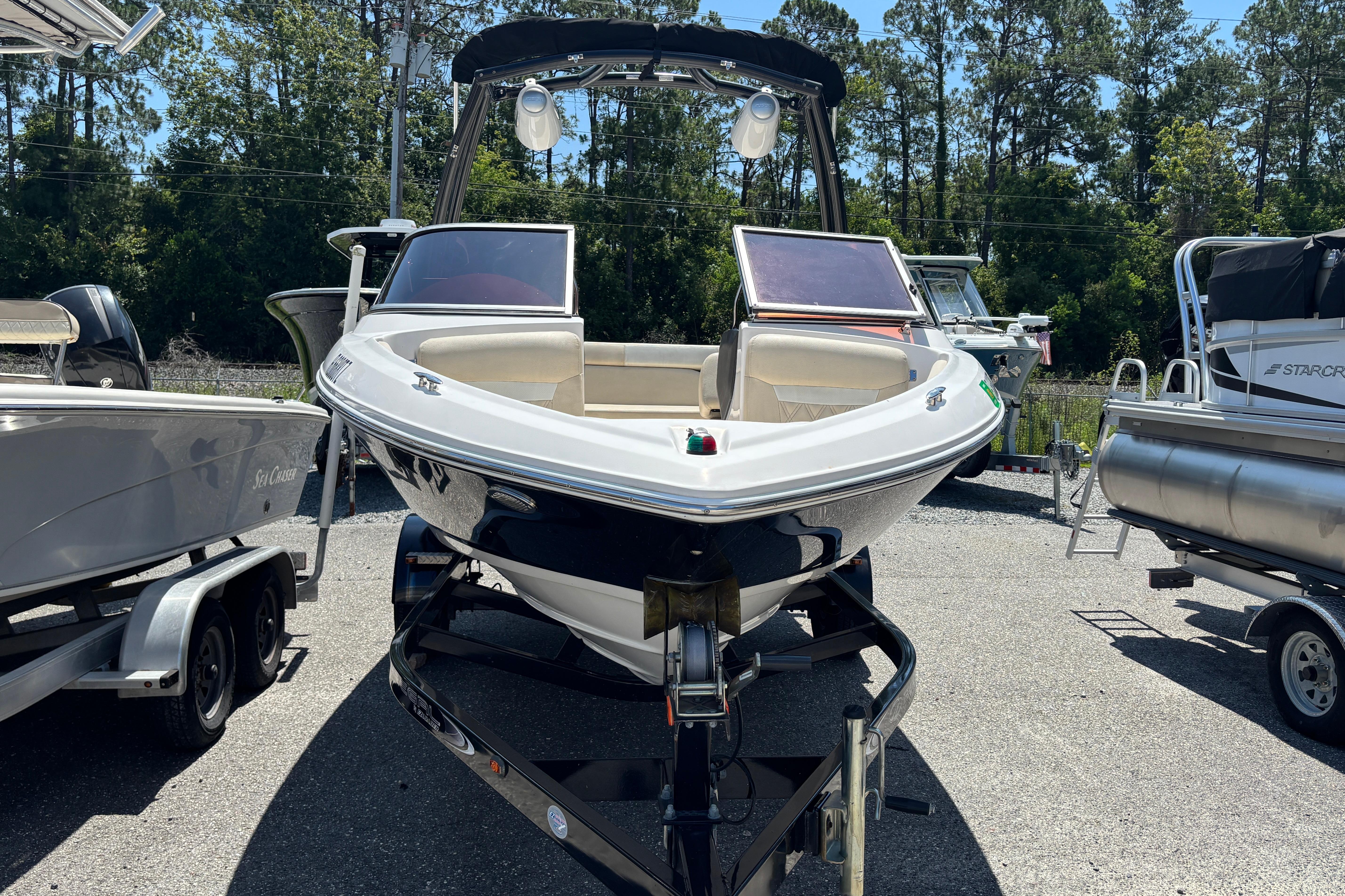 2018 Regal 1900 ES Bowrider boat on trailer, parked outdoors, surrounded by trees.