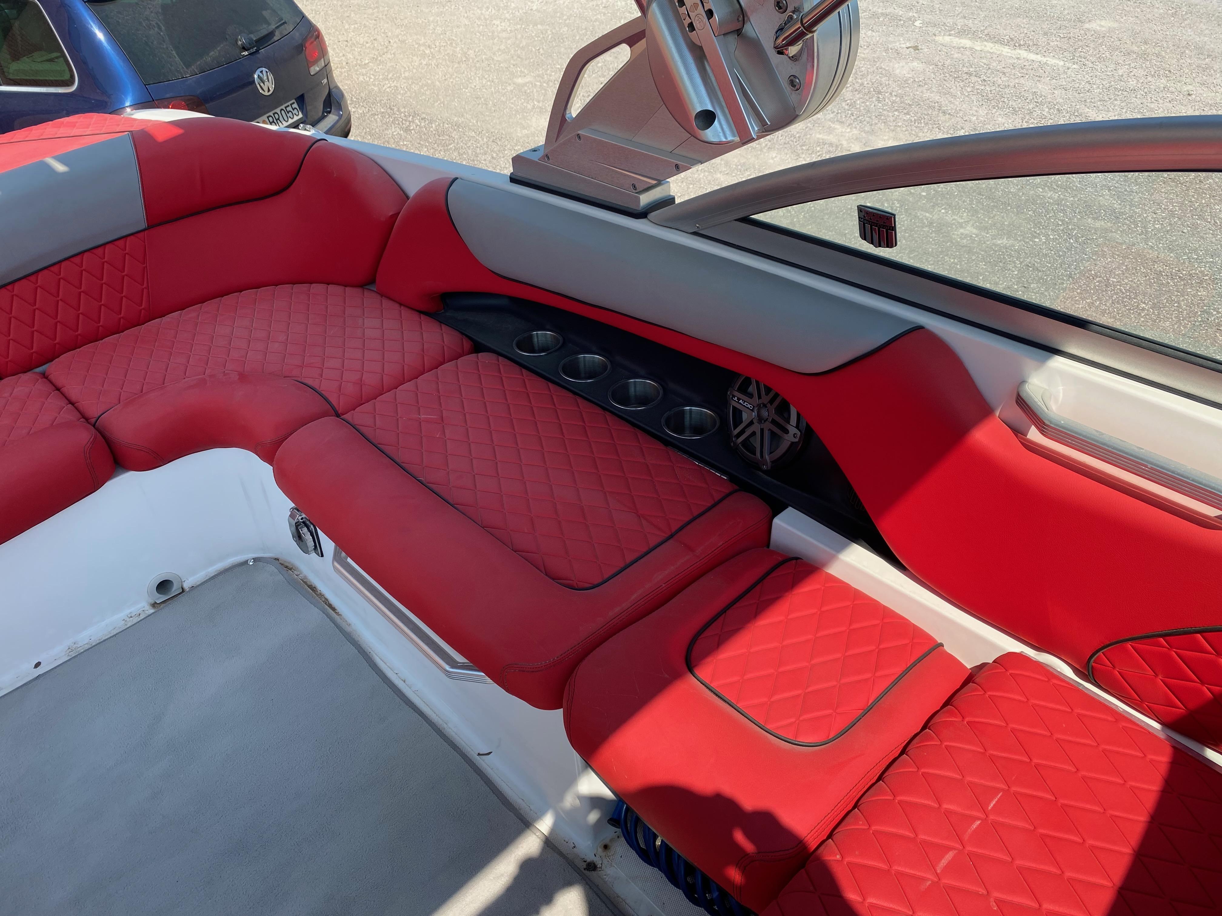 2013 MasterCraft X-35 boat interior with red quilted seats and cup holders.