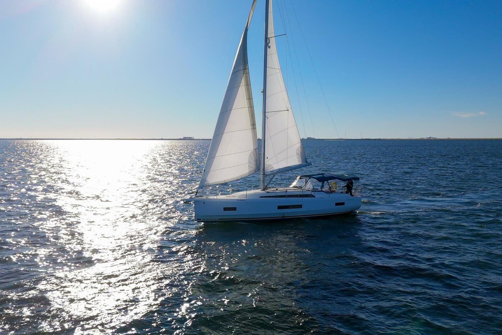2022 Beneteau Oceanis 40.1 sailing on open water under clear blue sky.