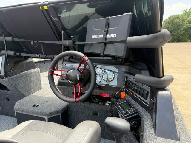 The image shows the cockpit of a 2025 Lund 2075 Impact XS boat with a modern helm.