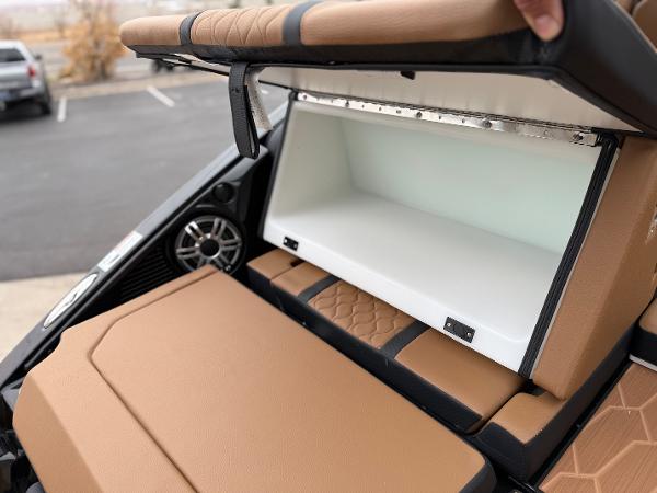 2025 Yamaha Boats 255XD storage compartment with tan seating and speaker detail.