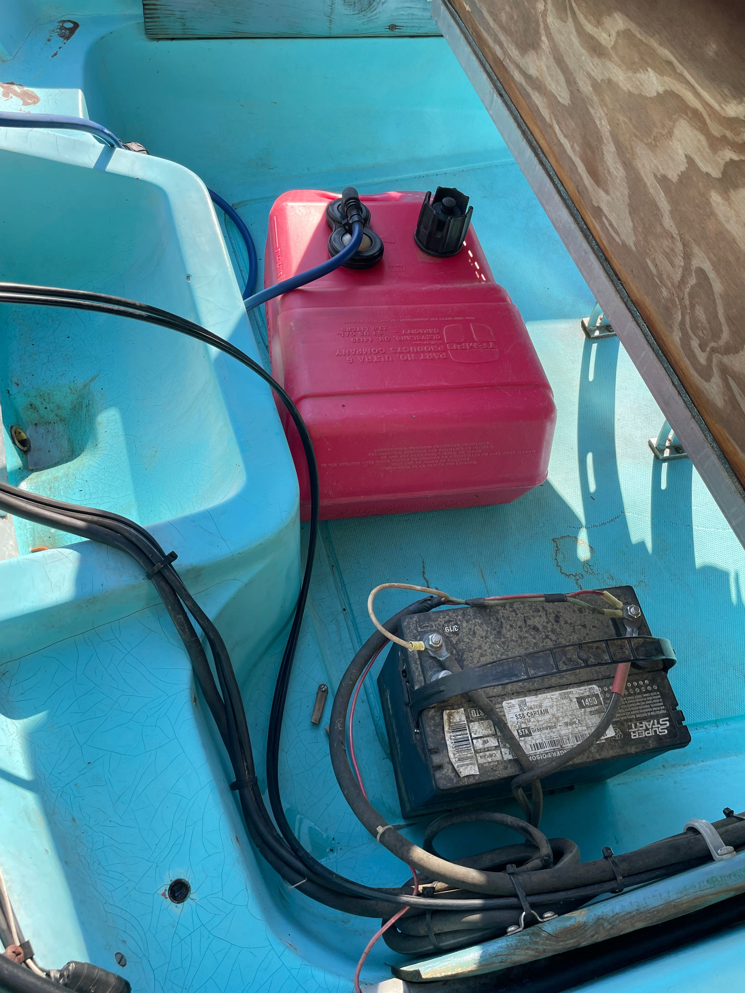 Interior of a 1964 Boston Whaler with battery and fuel tank.