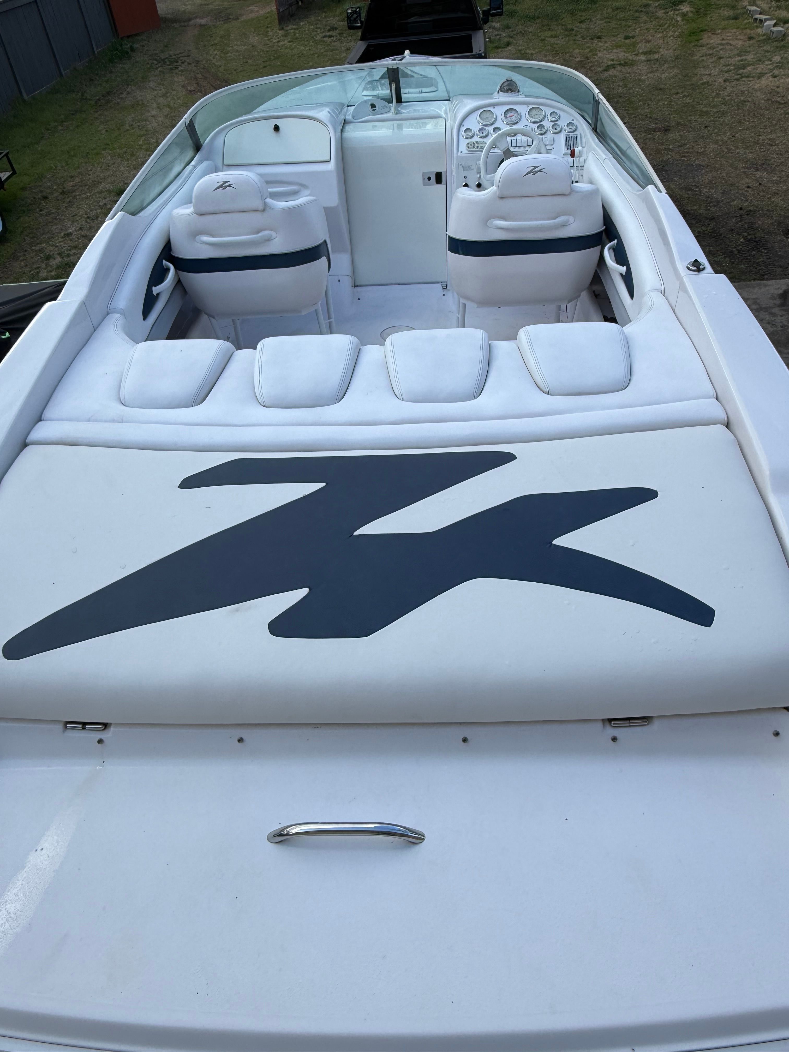The image shows the cockpit of a Donzi 28 ZX boat with white seats and a helm.