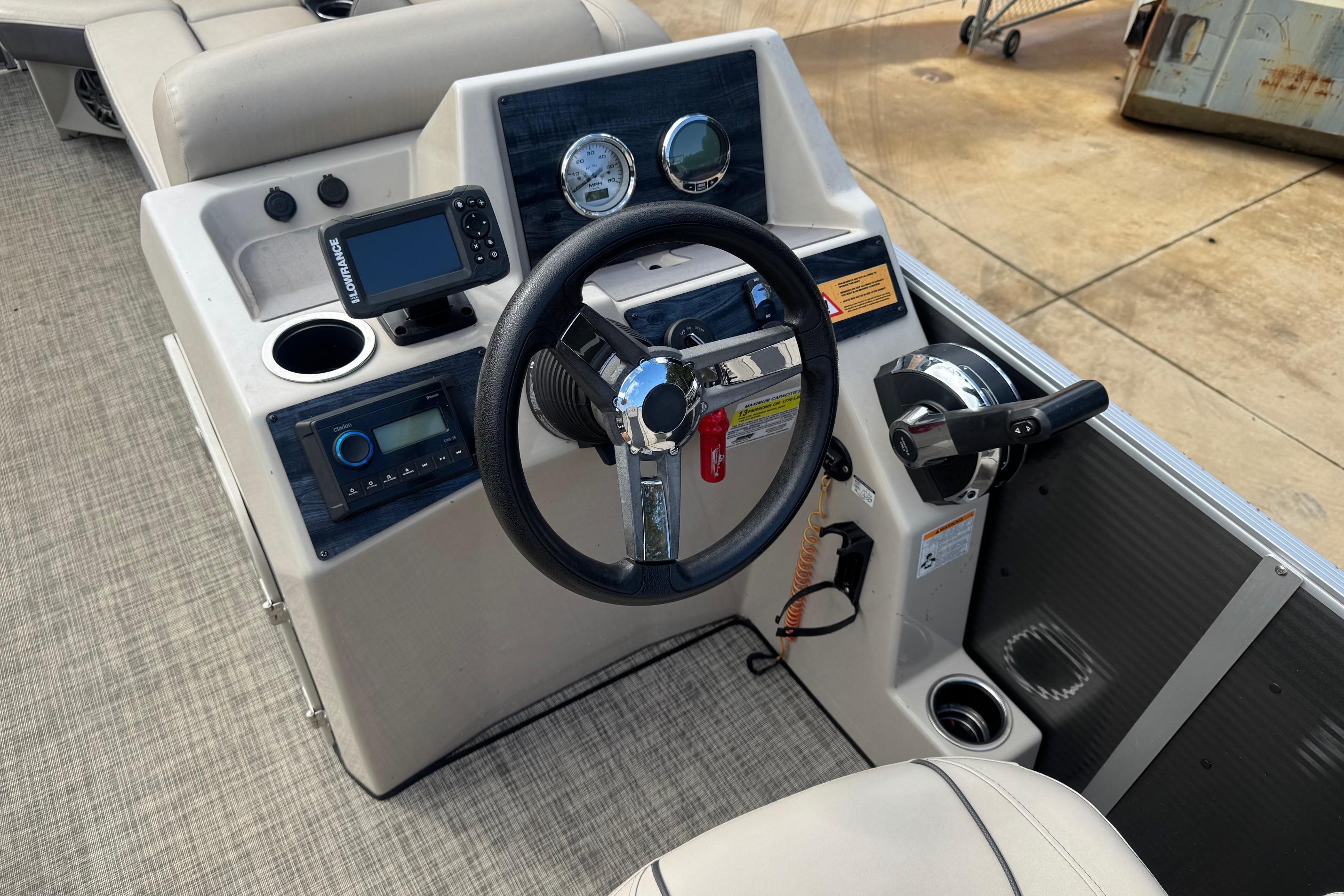 2023 Harris Cruiser 230 boat dashboard with steering wheel and navigation controls.
