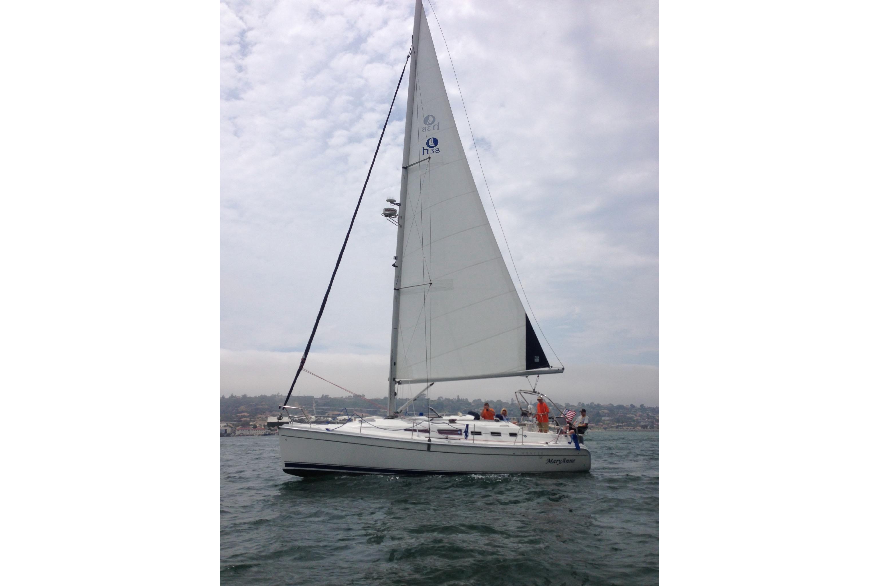 2009 Hunter 38 sailboat on open water under cloudy sky.