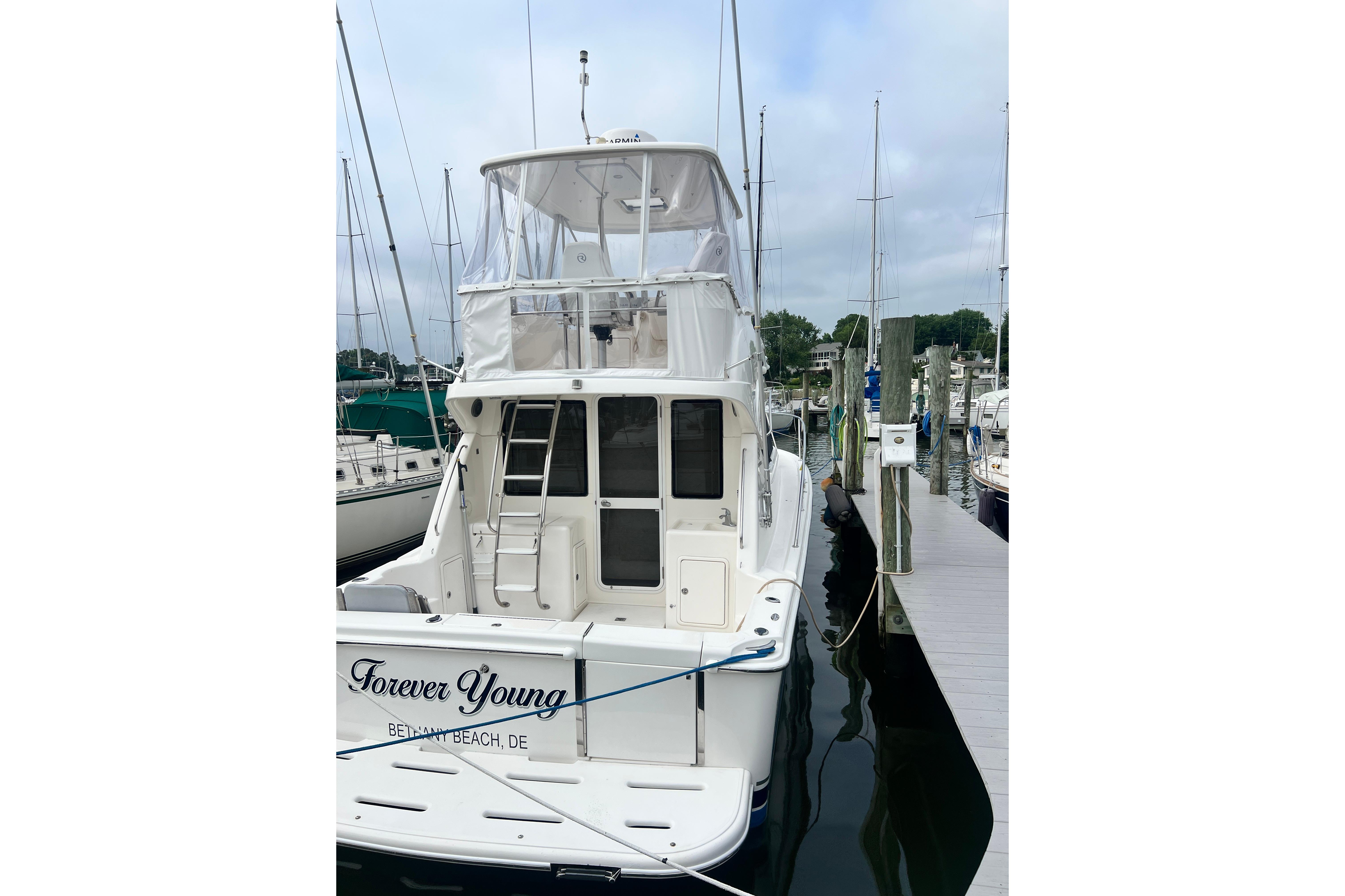 2007 Riviera 33 Flybridge yacht docked, named "Forever Young," at a marina.