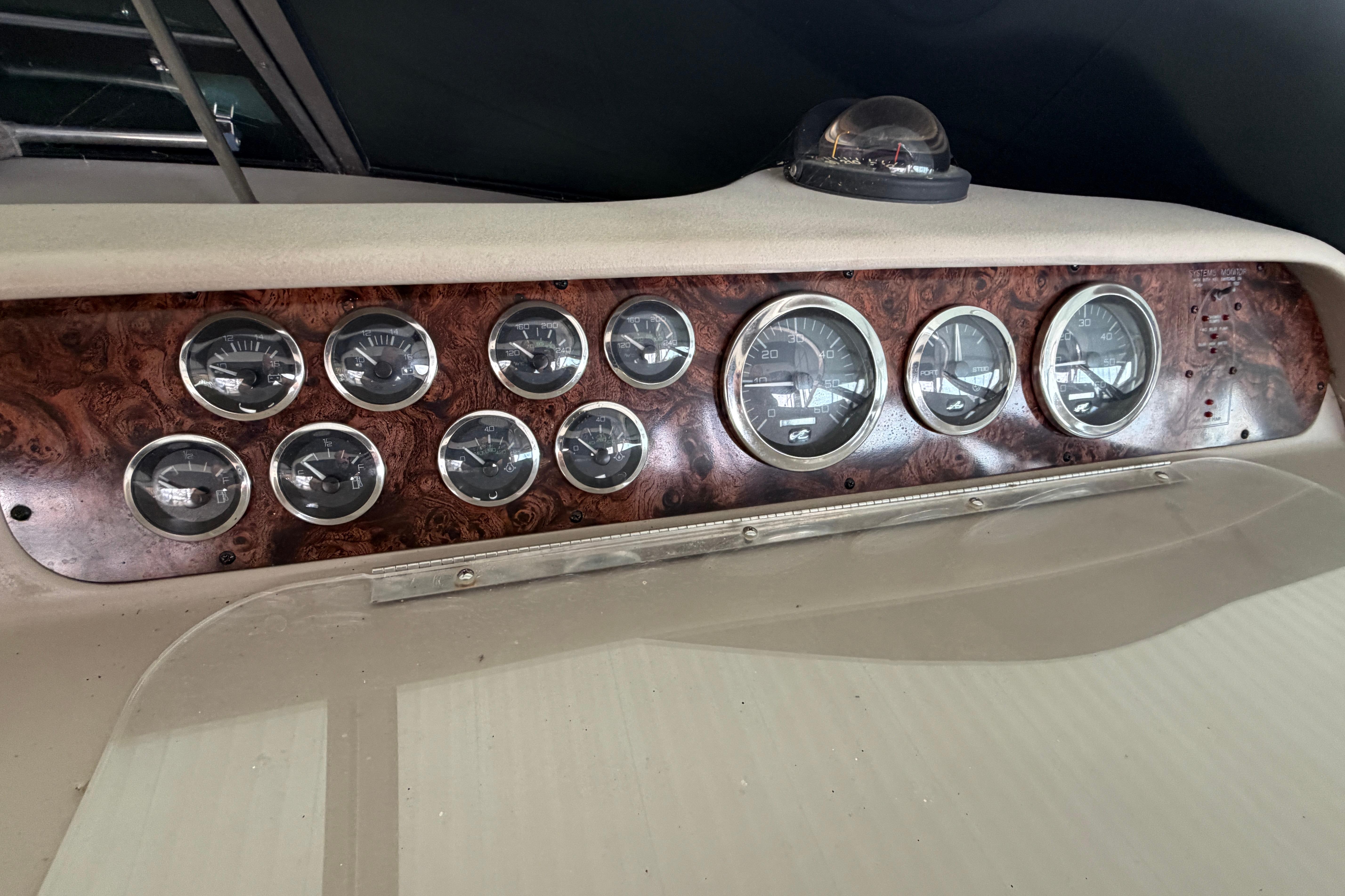 Dashboard of a 1999 Sea Ray 400 Sundancer with multiple gauges and wood paneling.