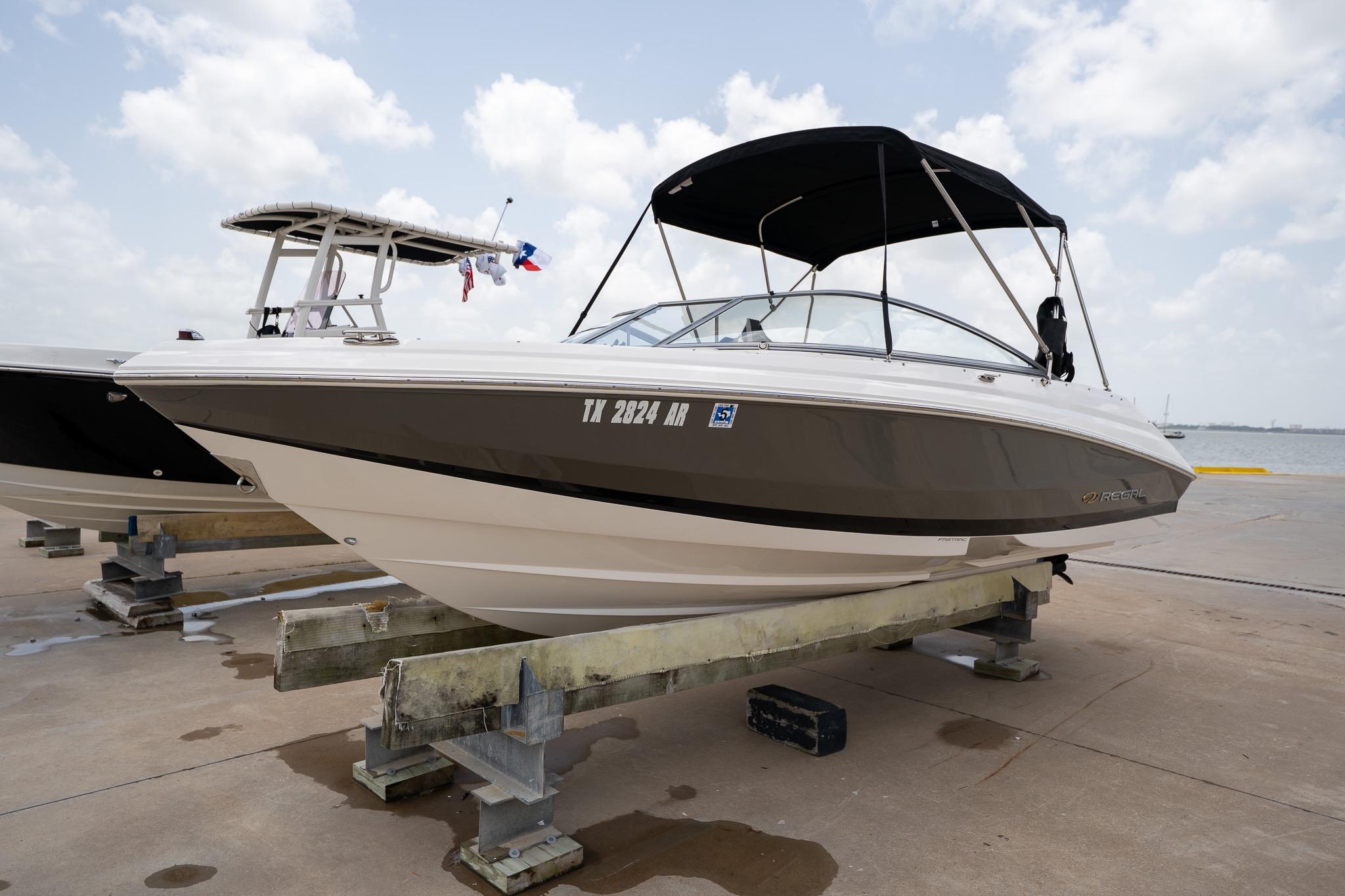 2008 Regal 2000 Bowrider boat on dock, featuring sleek design and canopy under cloudy sky.