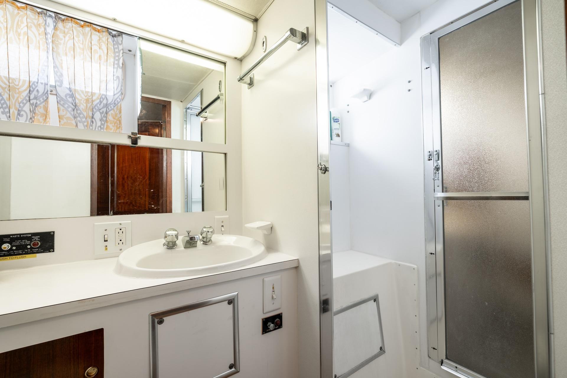 Bathroom interior of 1978 Hatteras 53 Yacht Fisherman with sink and shower.
