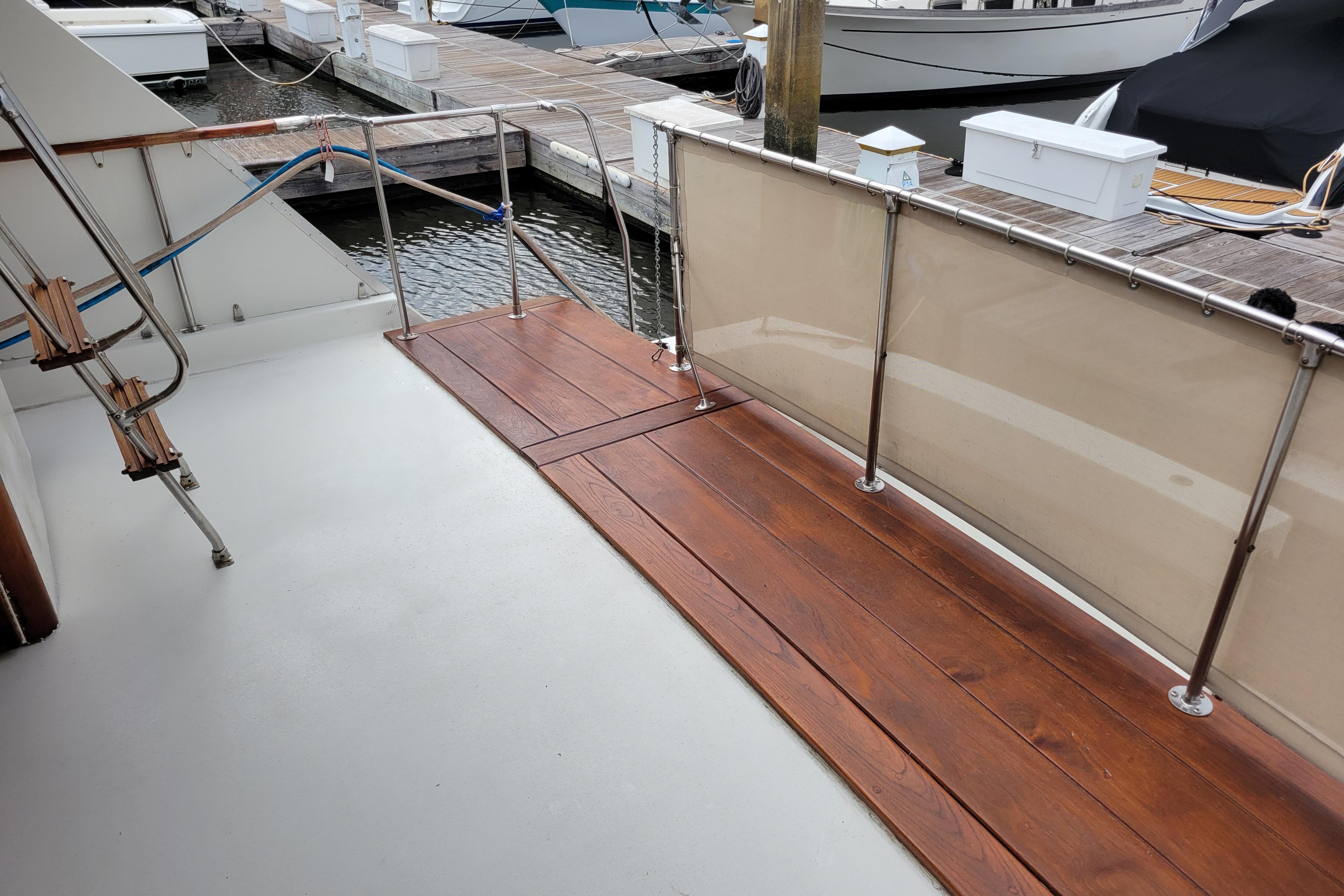 1980 Hatteras 53 Yacht Fisherman deck with wooden flooring and dock view.