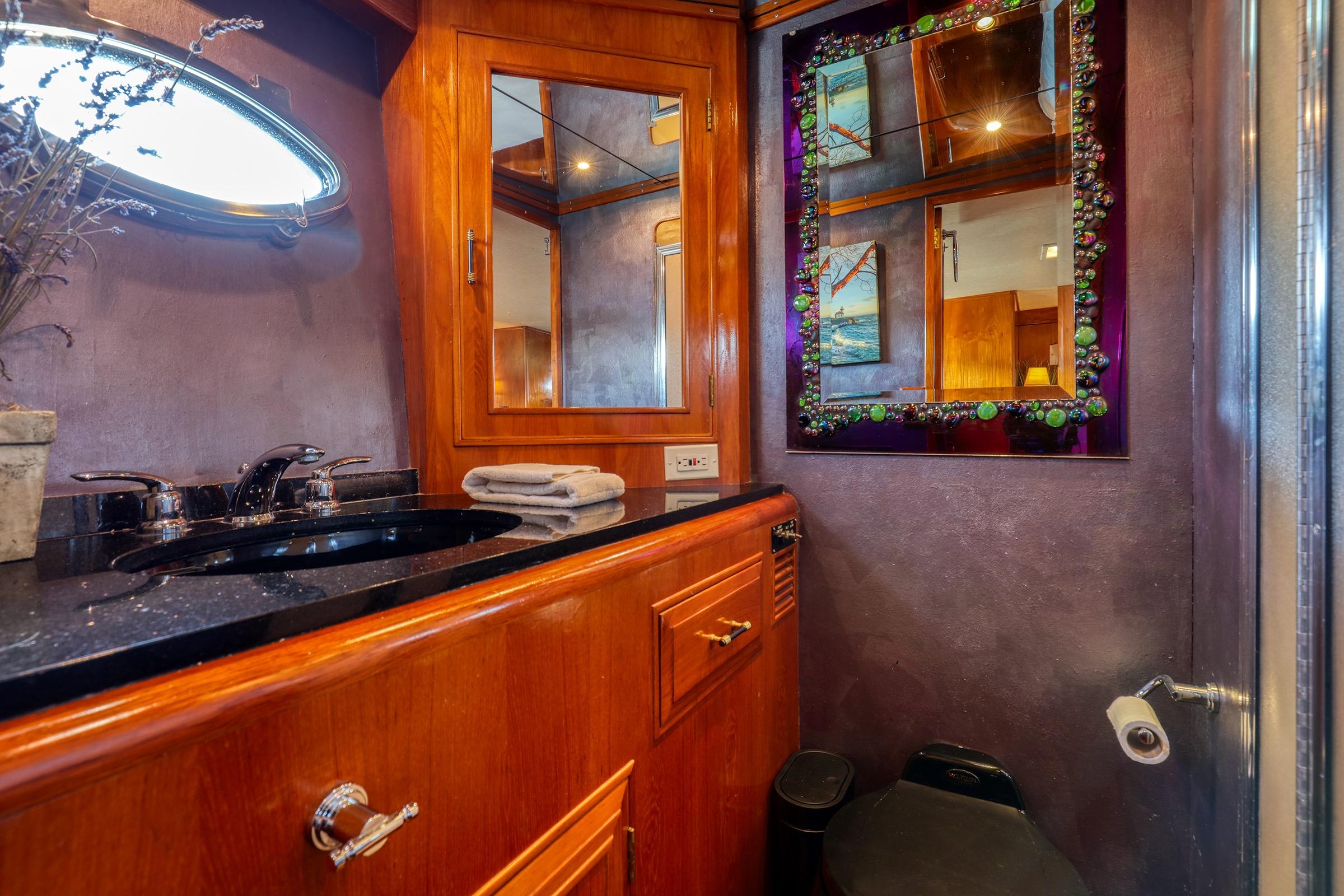 Luxurious bathroom in 1987 Ocean Alexander 480 Sport Sedan yacht with elegant wood cabinetry.