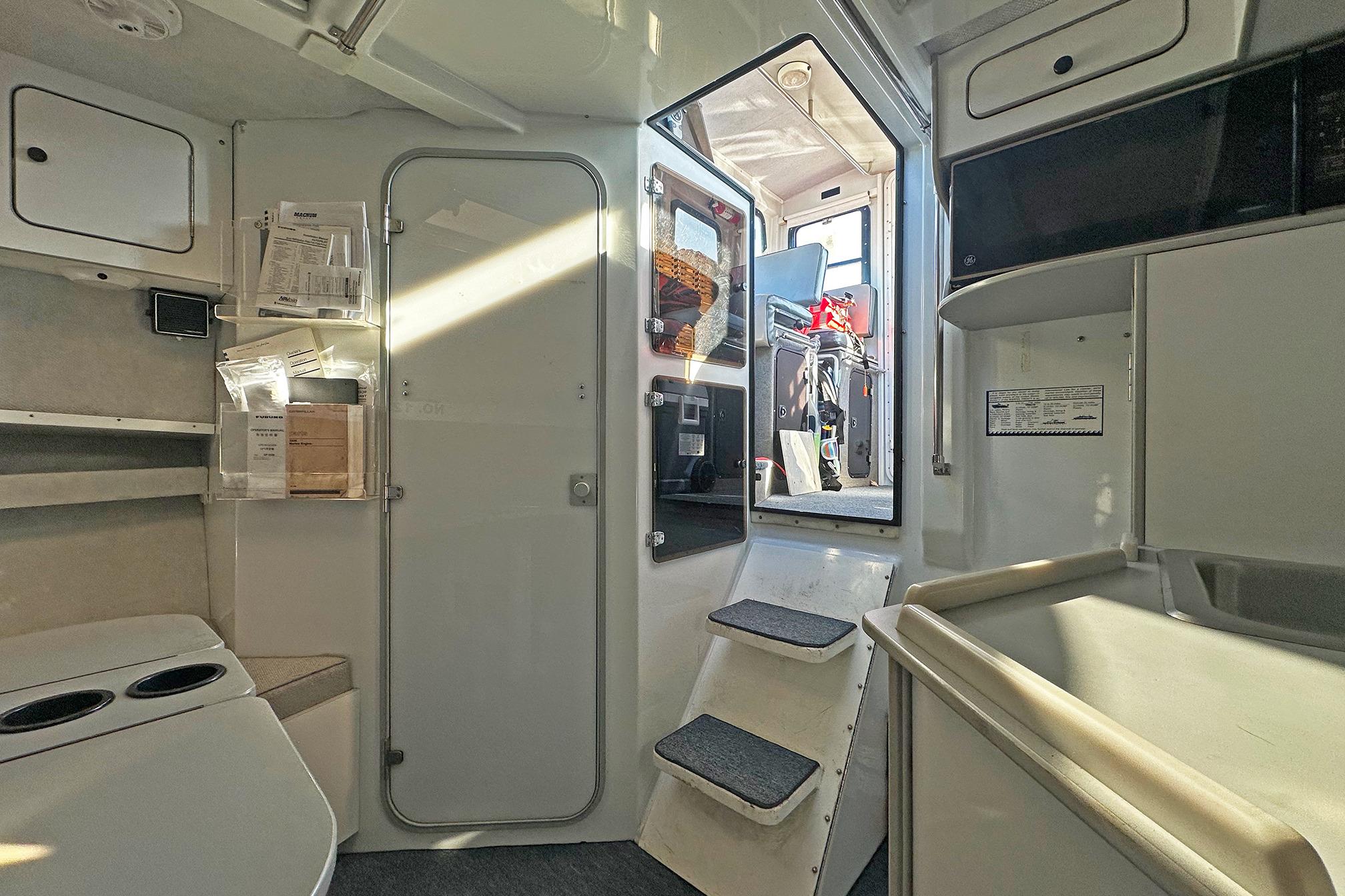 Interior of a 1990 Boston Whaler 36 Defiance boat, featuring steps and storage compartments.