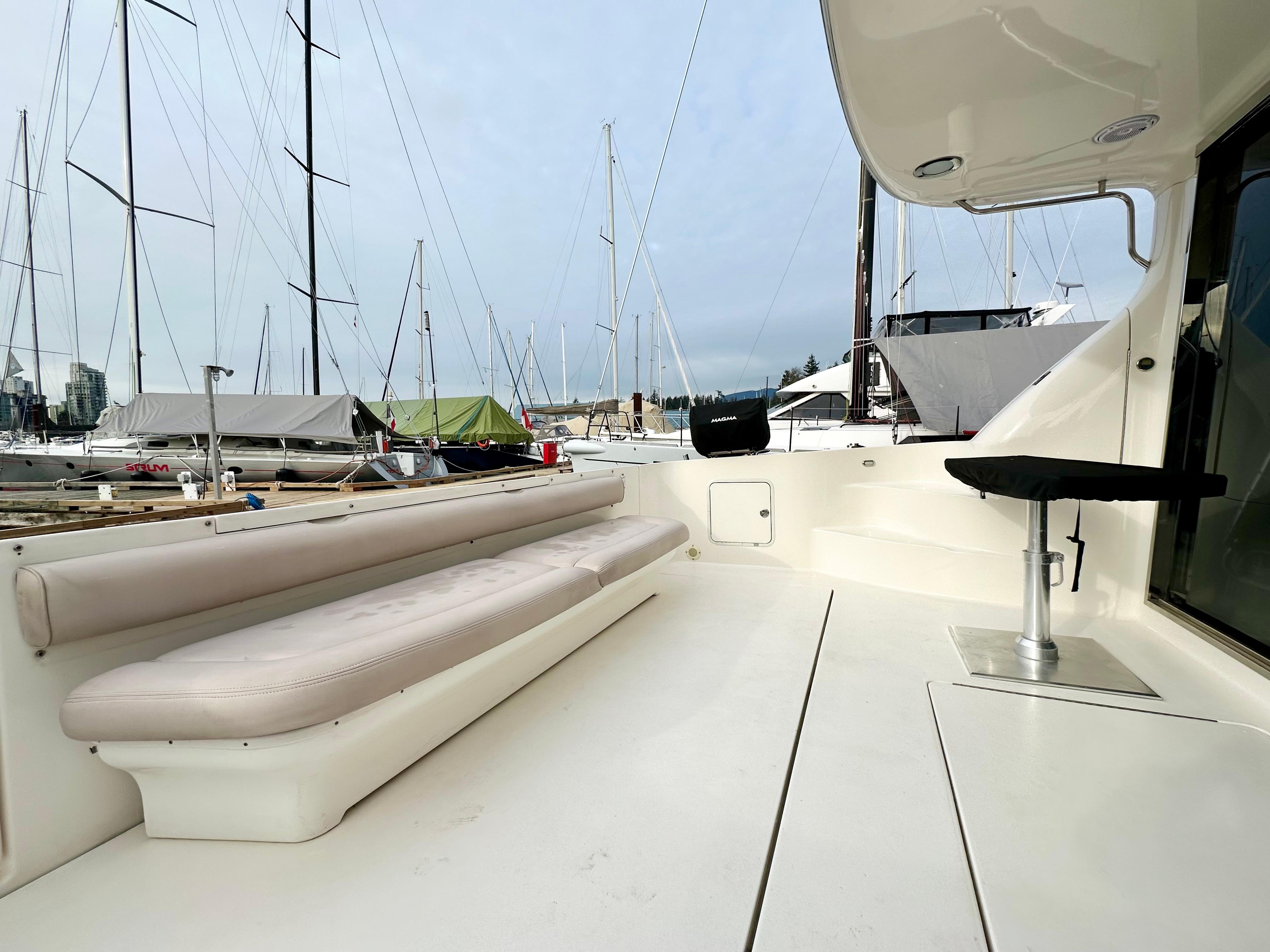 2002 Sea Ray 560 Sedan Bridge yacht deck with seating, docked at marina.