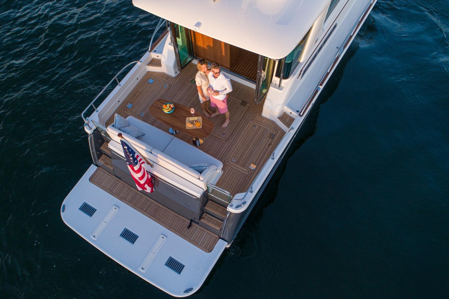 Couple enjoying sunset on 2025 Sabre 58 Salon Express yacht deck.