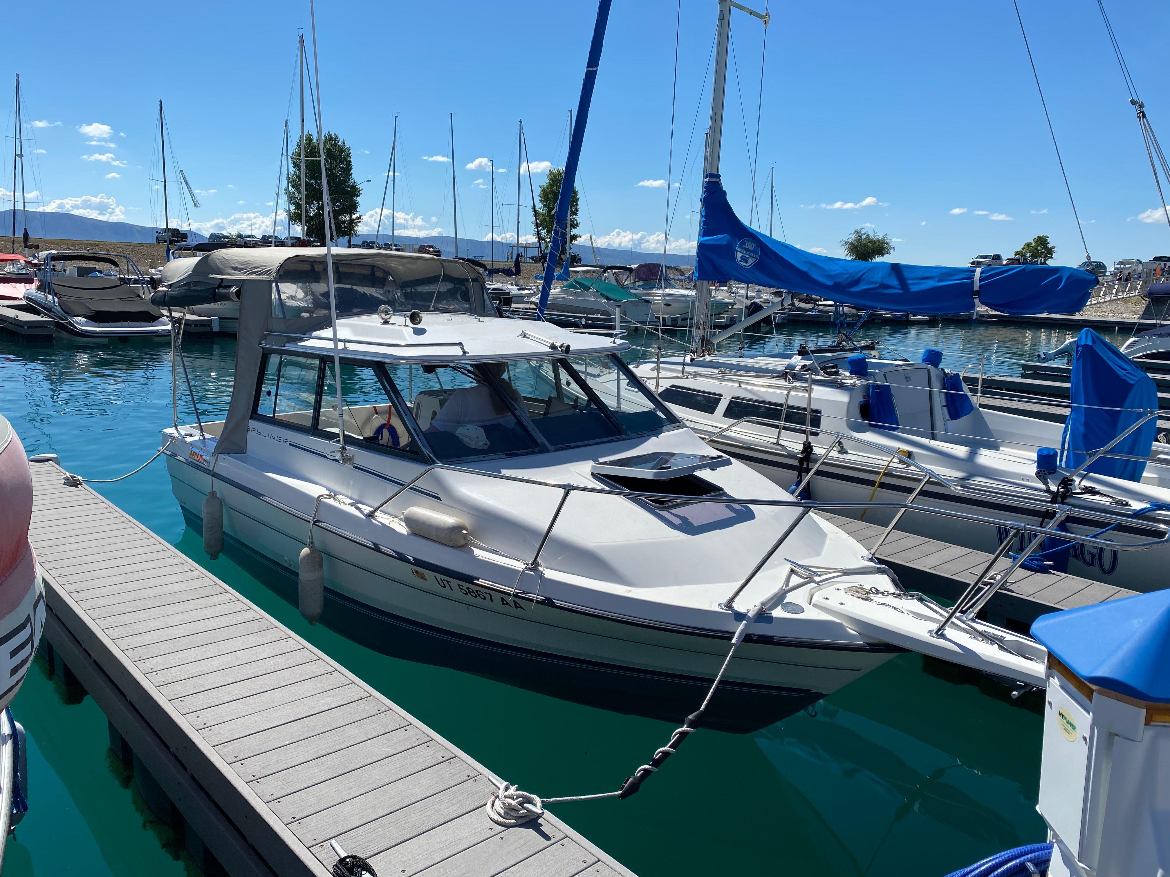A 1991 Bayliner 2159 docked in a marina on a sunny day.