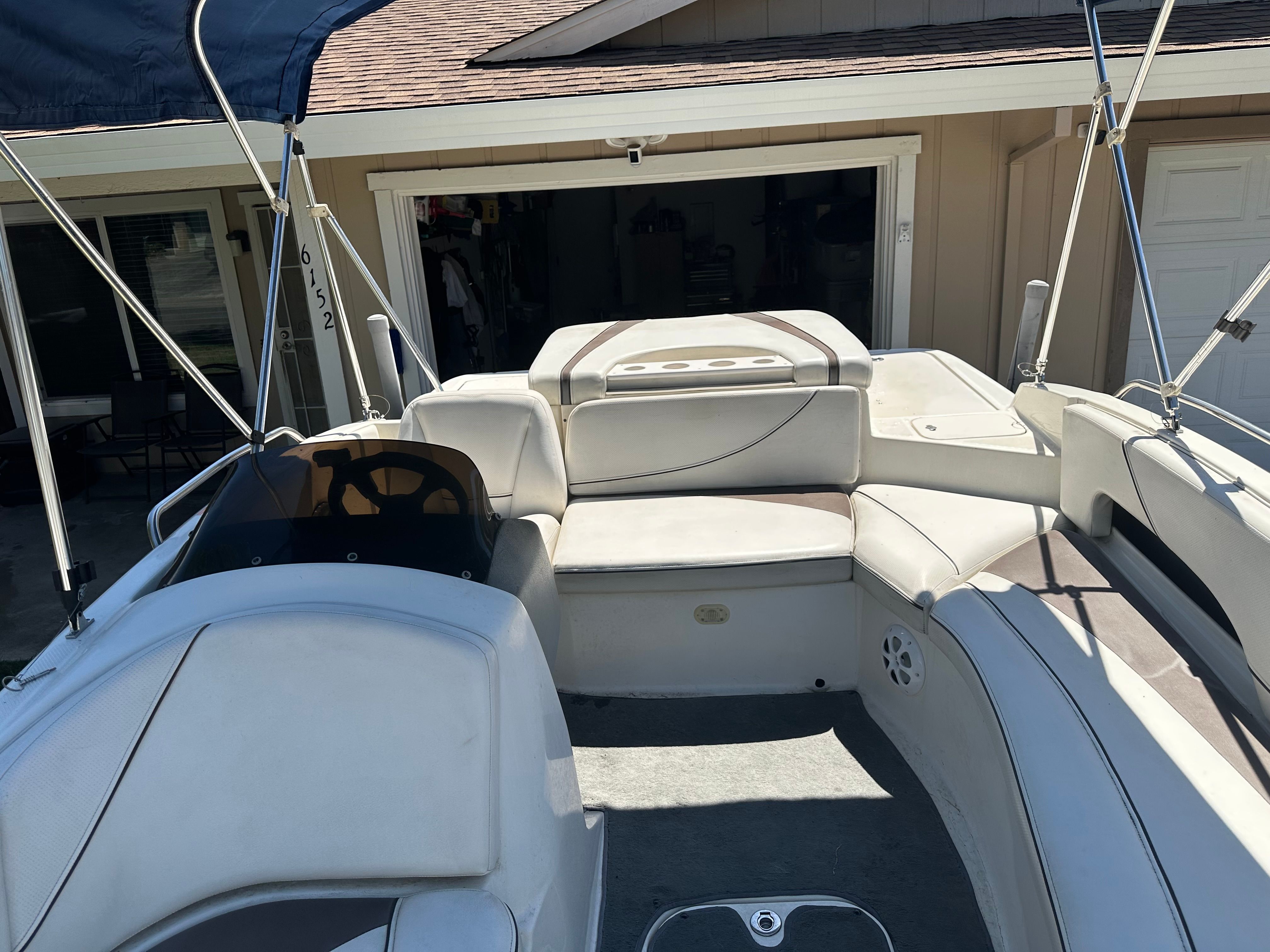 The image shows the interior of a Bayliner boat with white seating and a blue sunshade.