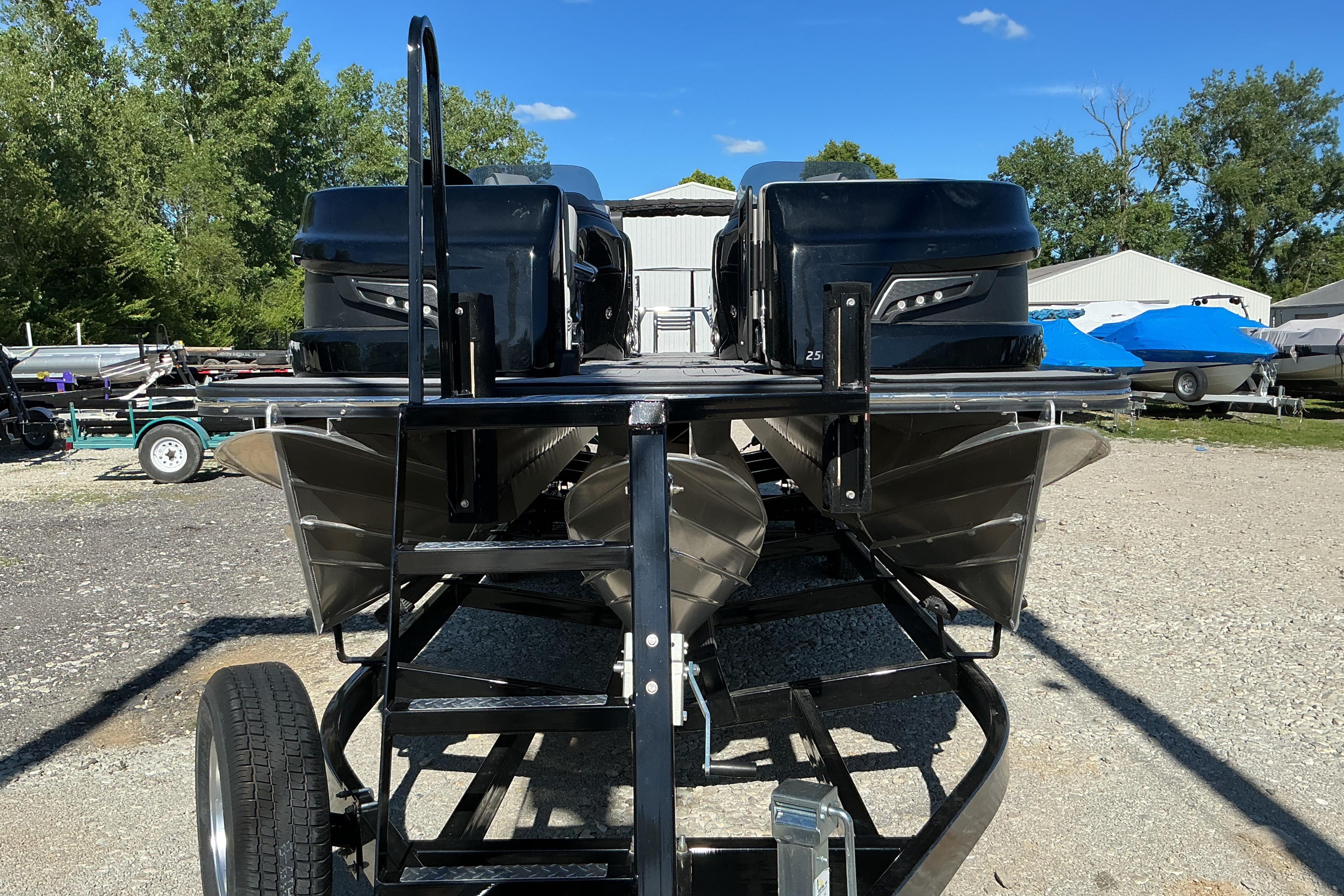 2024 Manitou 25 X-Plode XT SRS pontoon boat on trailer, outdoor setting.