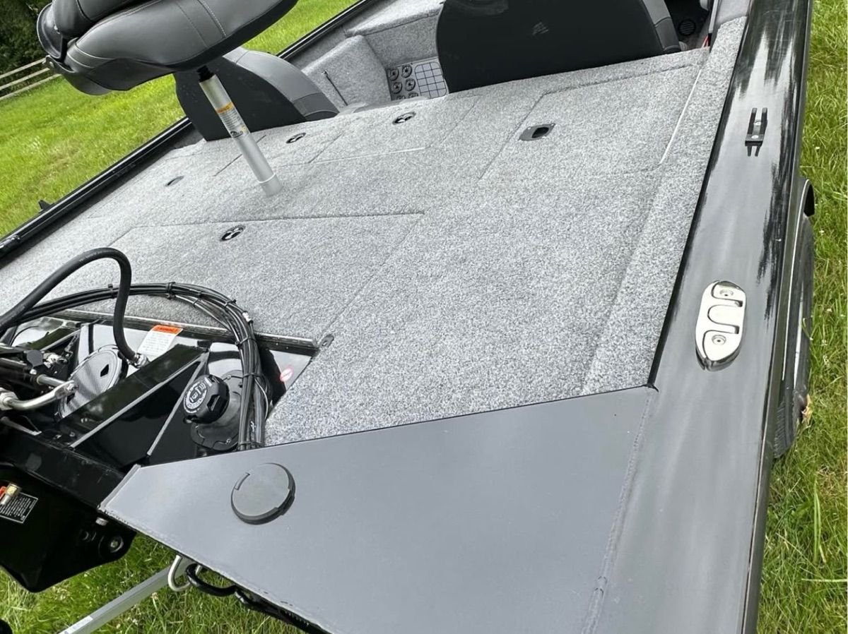The image shows the deck of a 2022 Bass Tracker 195TXW with gray carpeting.