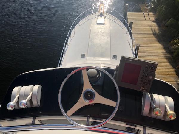 1997 Bertram Convertible boat helm with steering wheel and navigation equipment.