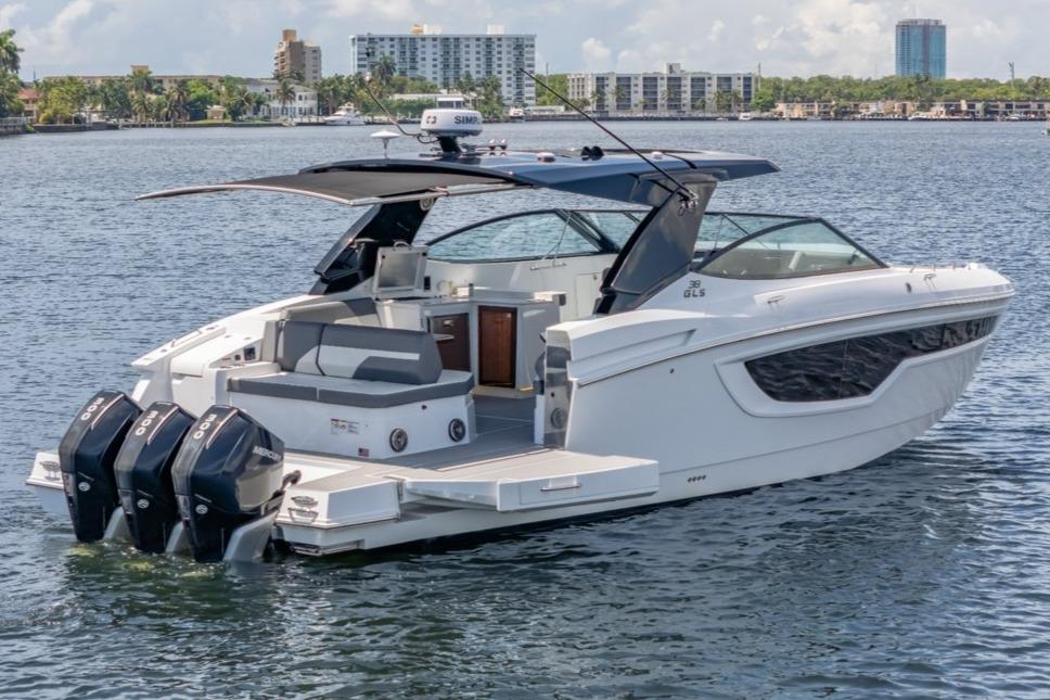 2021 Cruisers Yachts 38 GLS on water, featuring triple outboard engines and sleek design.