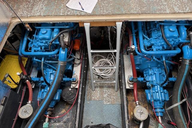 Engine room of a 1982 Lancer 45 Motorsailer with dual blue engines and ladder access.