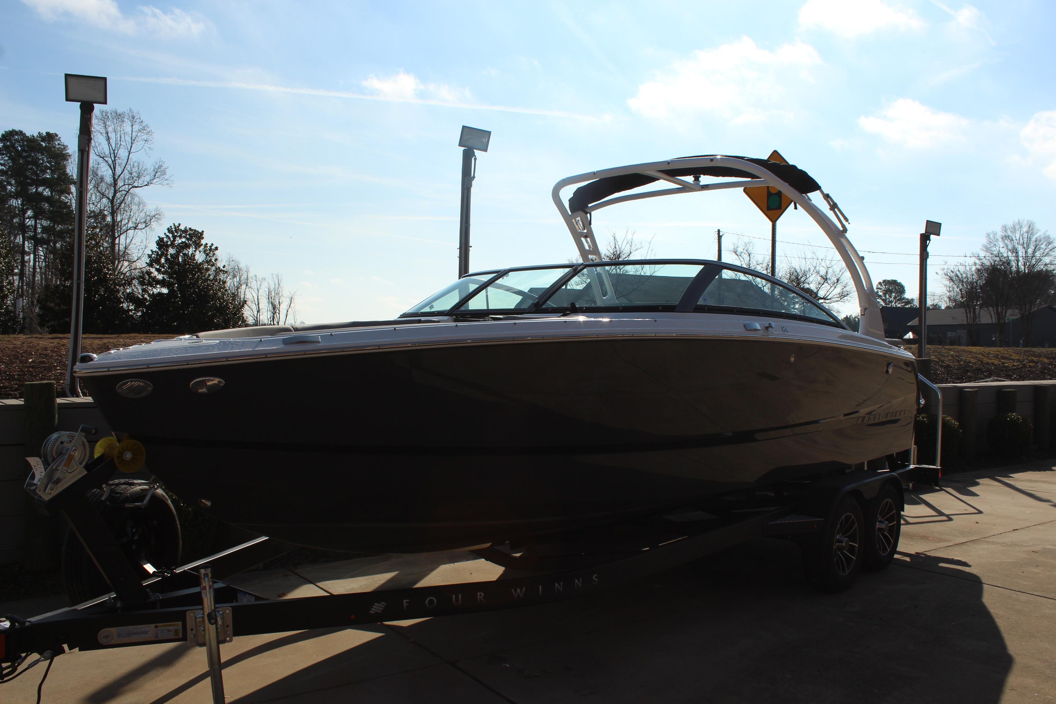 2026 Four Winns H4 boat on trailer under clear sky.