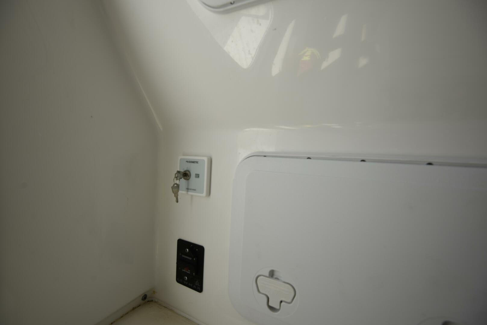 Interior view of 2023 Sea Pro 239 Deep V CC boat, featuring a control panel and storage compartment.