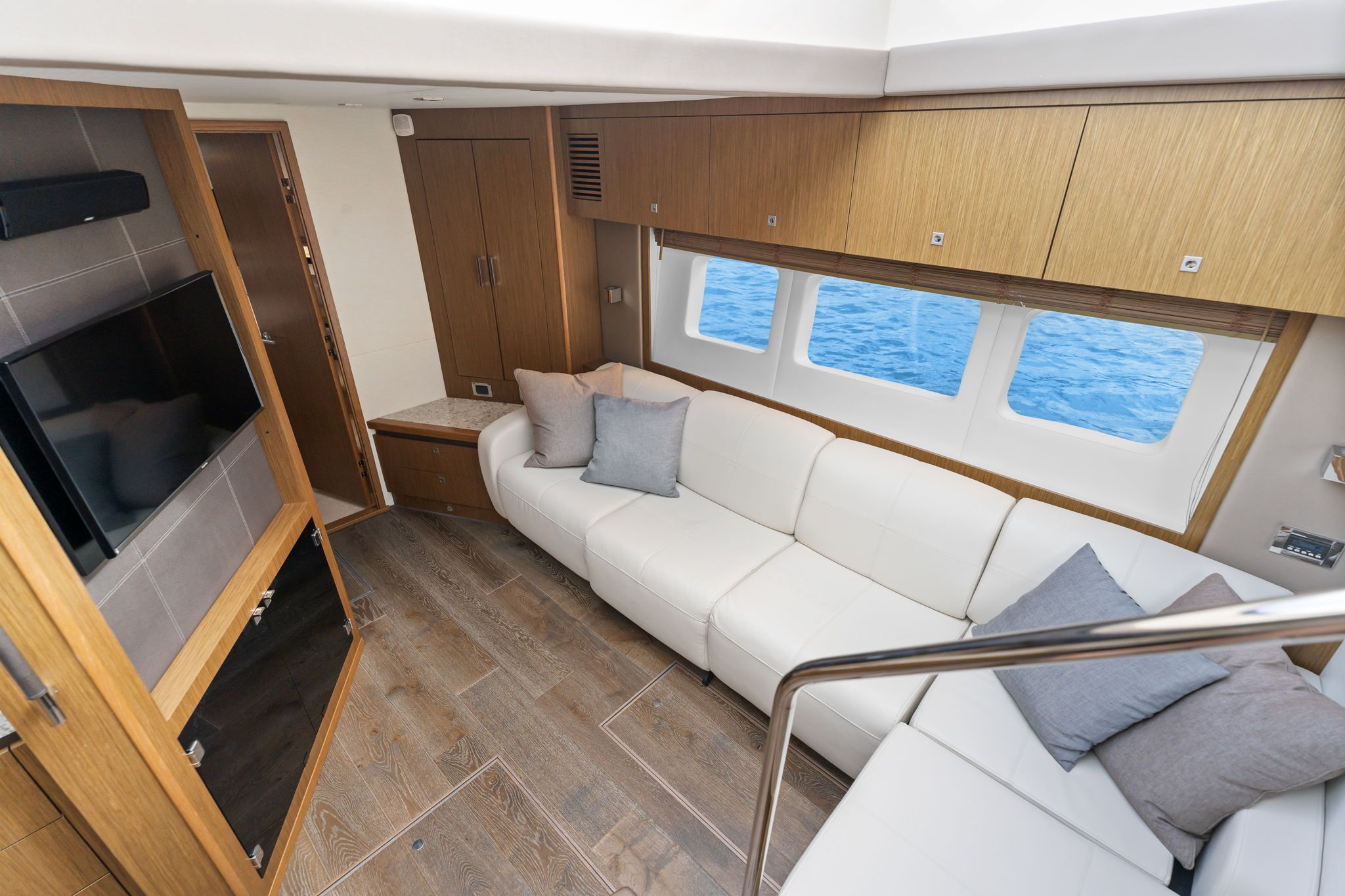 Interior of the Sea Ray Sundancer 510 with white sofas and wooden cabinetry.