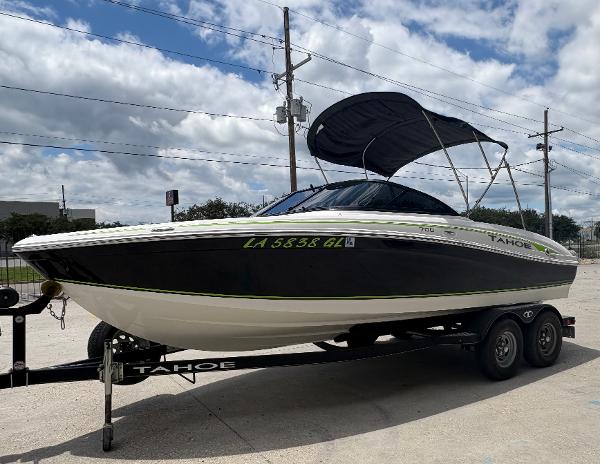 2019 Tahoe 700 boat on trailer with canopy, parked outdoors under cloudy sky.