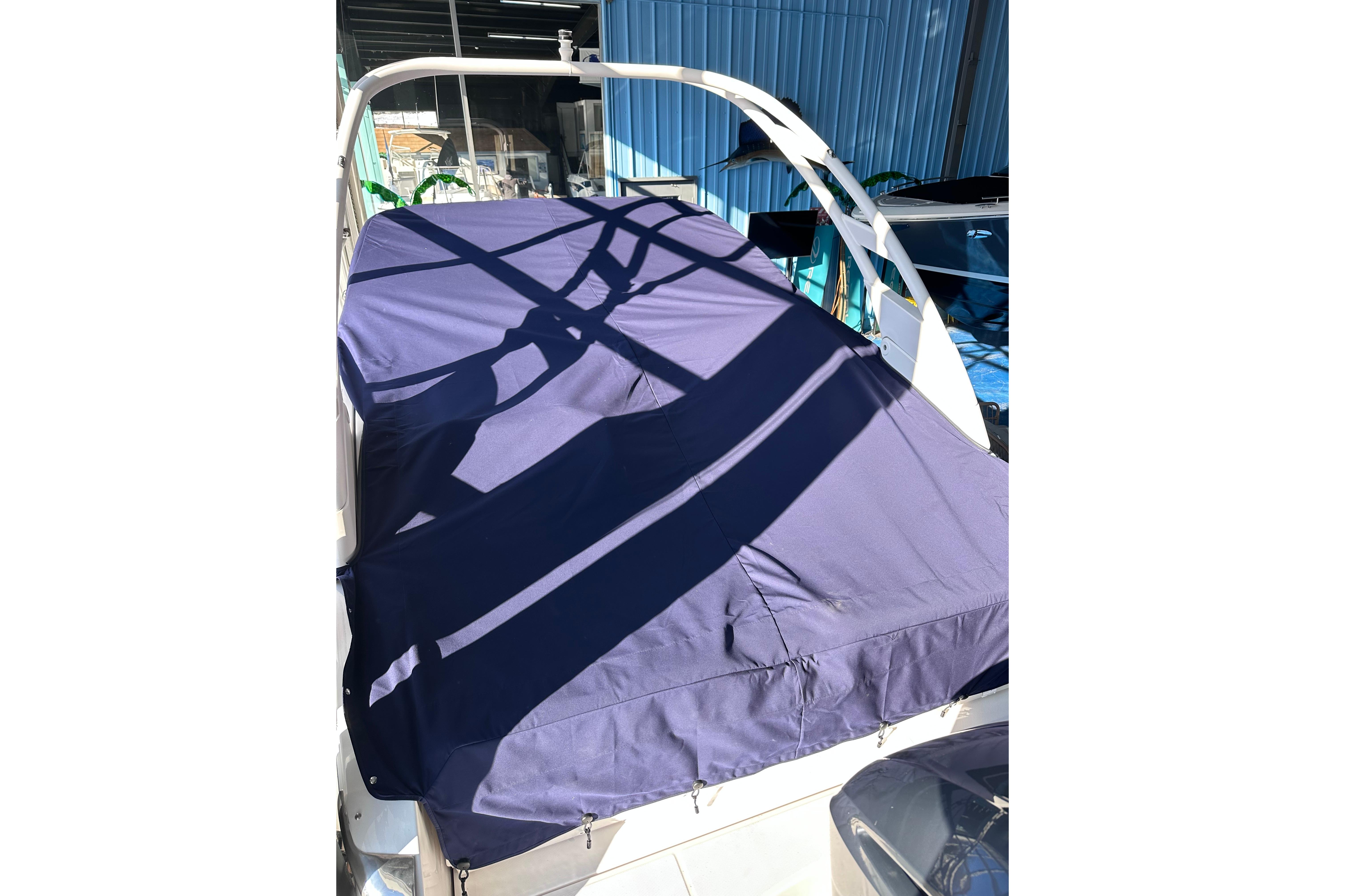 2026 Regal LX4 boat with blue cover in a marina setting.