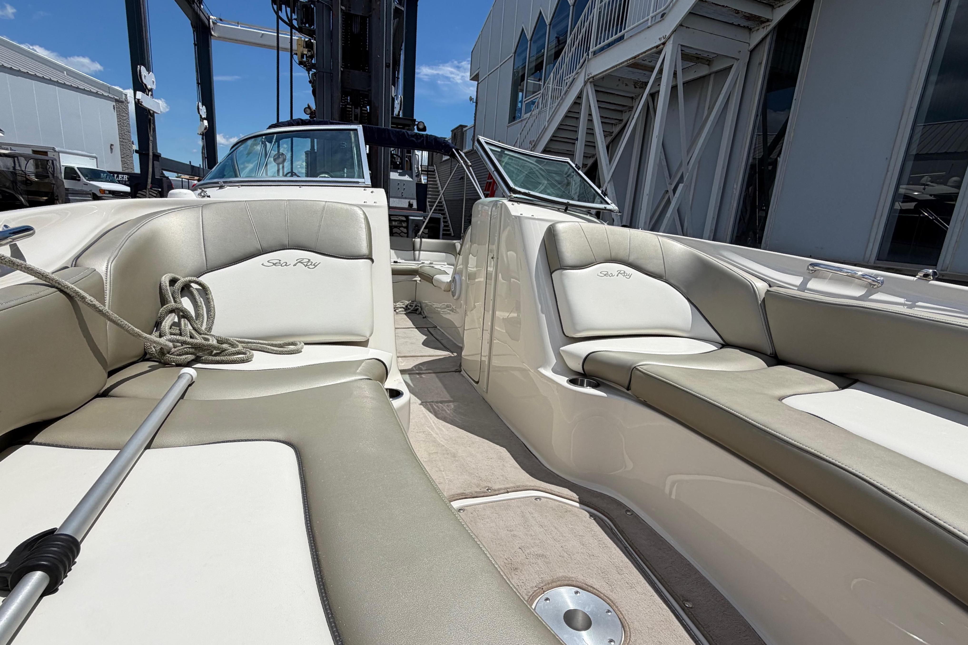 2004 Sea Ray 240 Sundeck interior with beige seating, docked near a marina.