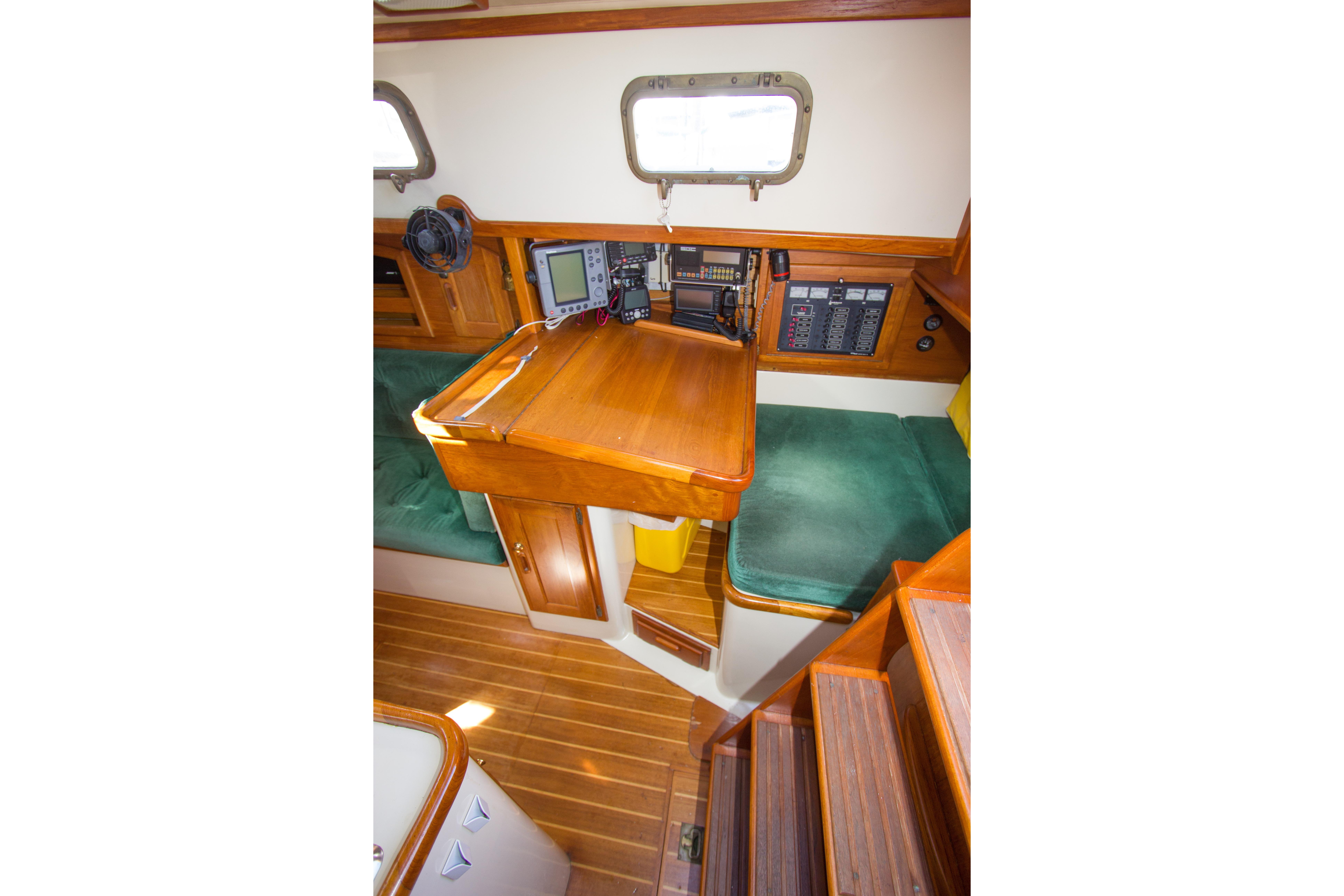 Interior of 1992 Pacific Seacraft 34 sailboat with navigation station and green seating.