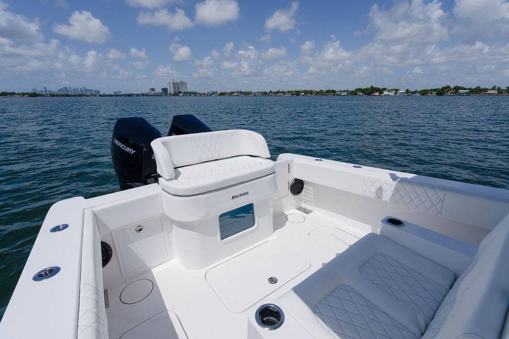 2027 Reef Runner 340 boat with spacious seating, dual Mercury engines, and scenic ocean view.