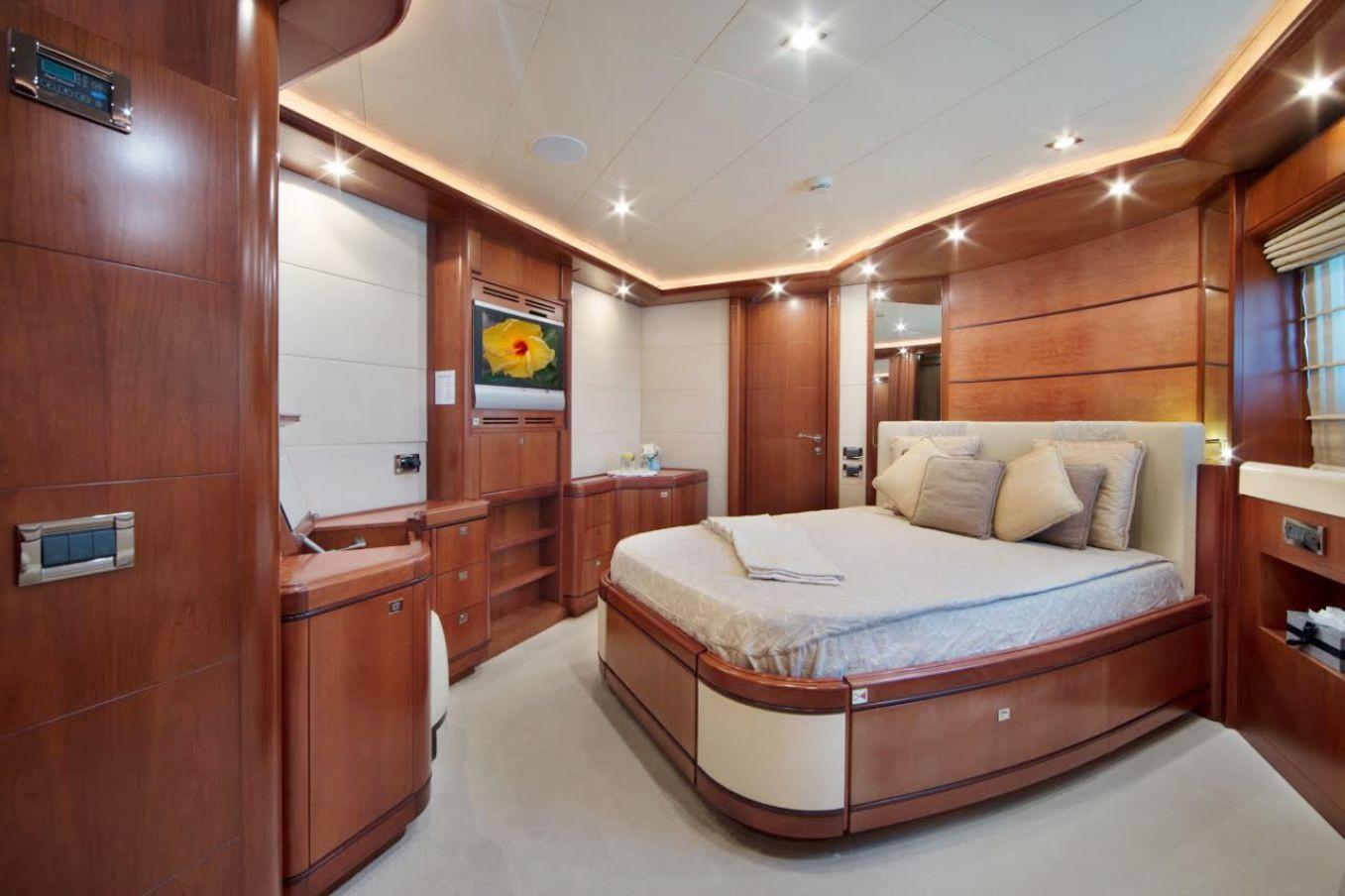 Luxurious yacht bedroom with wood paneling, modern lighting, and a cozy bed. CRN 128, 2007 model.
