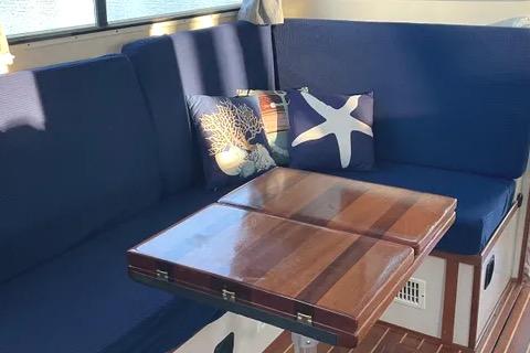 Interior of 1997 Rosborough Trawler with blue seating and decorative pillows.