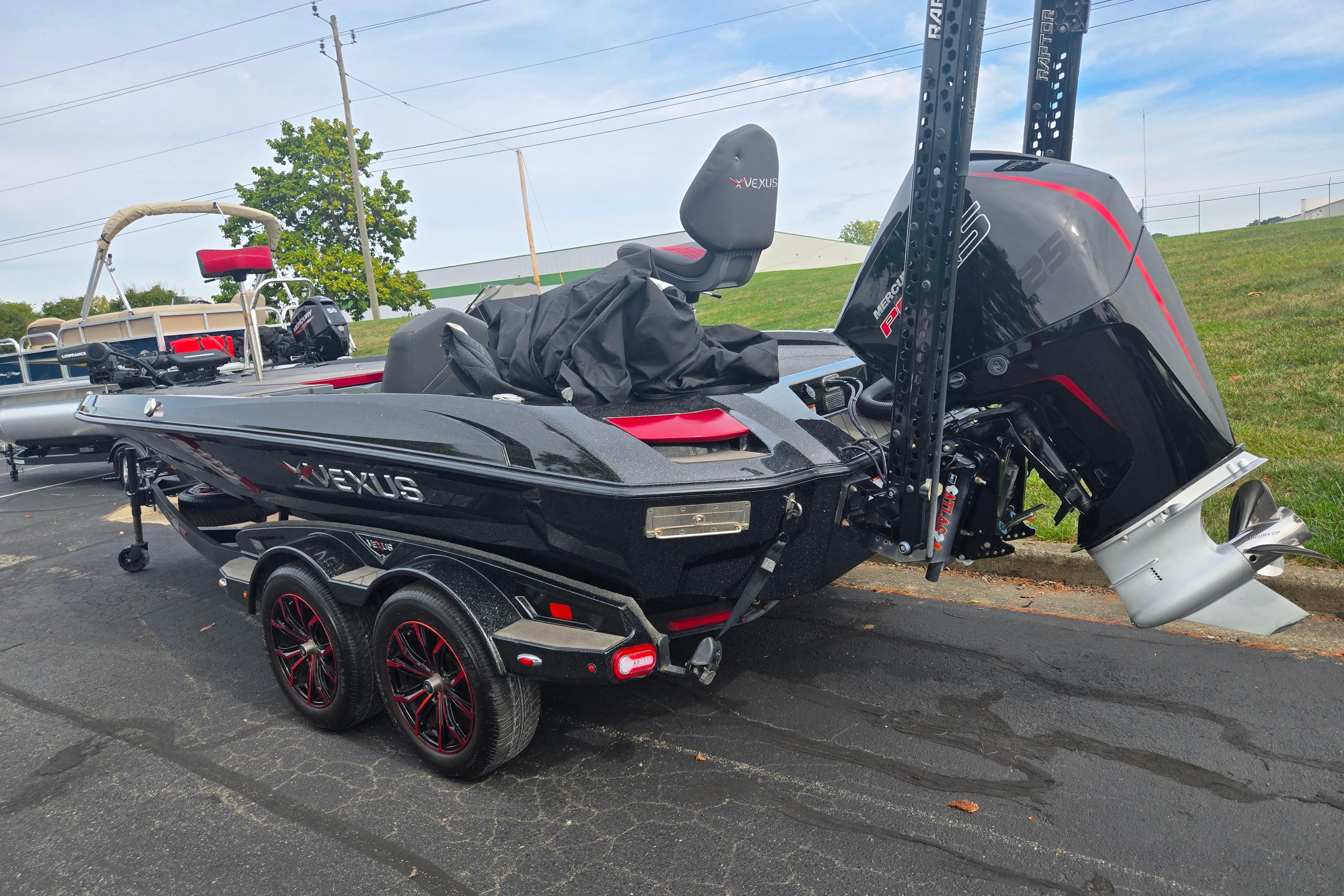 2022 Vexus VX20 boat with Mercury engine, parked on pavement, featuring sleek black design.