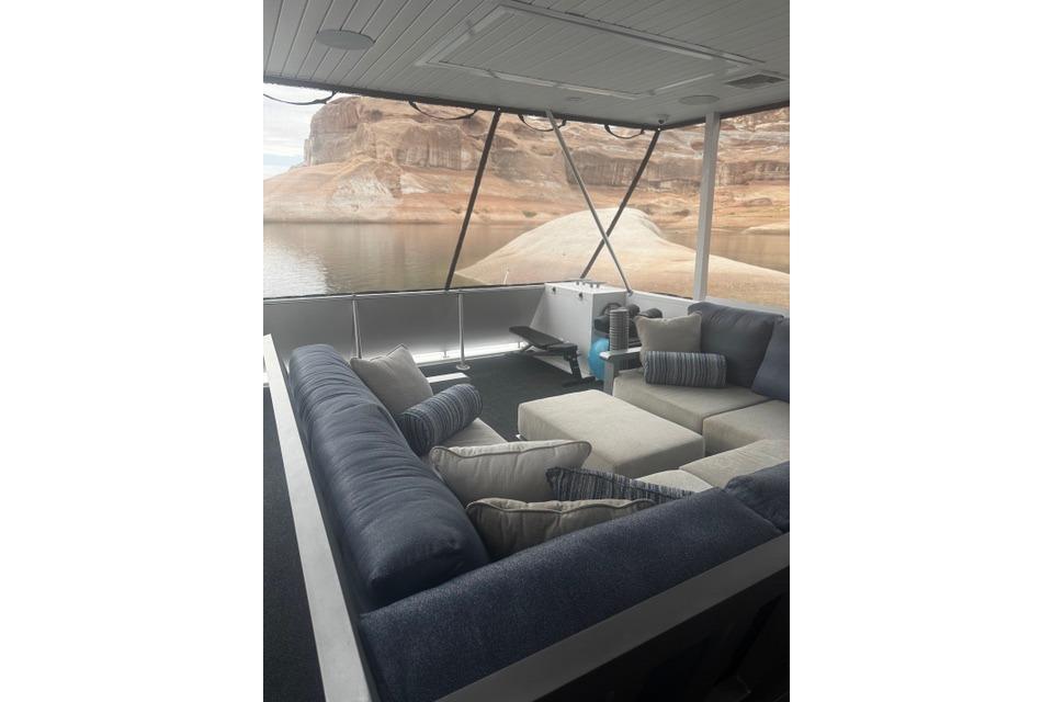 Luxurious seating area on Adonia's 2021 "The Queen Elizabeth" yacht with scenic water view.