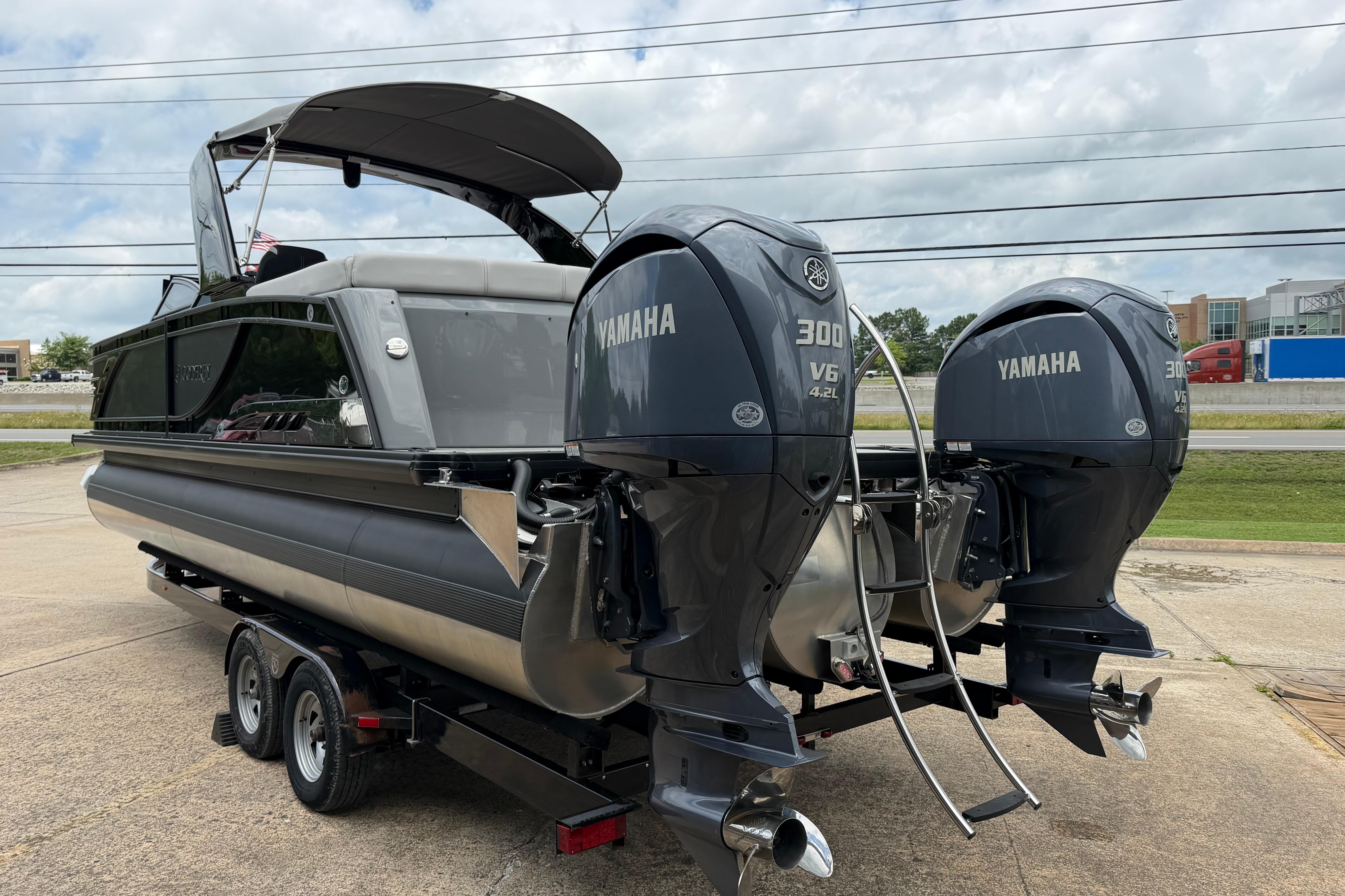2023 Godfrey Sanpan 2700 ULW Twin pontoon boat with dual Yamaha 300 engines on trailer.