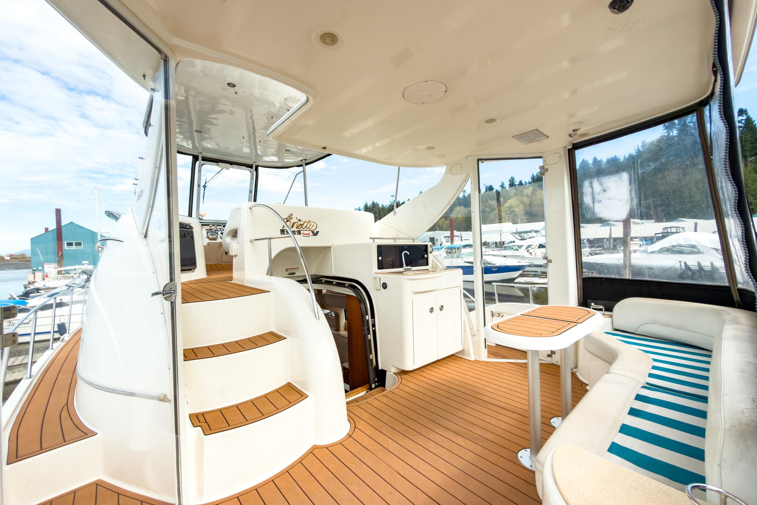 2005 Meridian 459 Motoryacht interior with seating, table, and helm station, docked at marina.