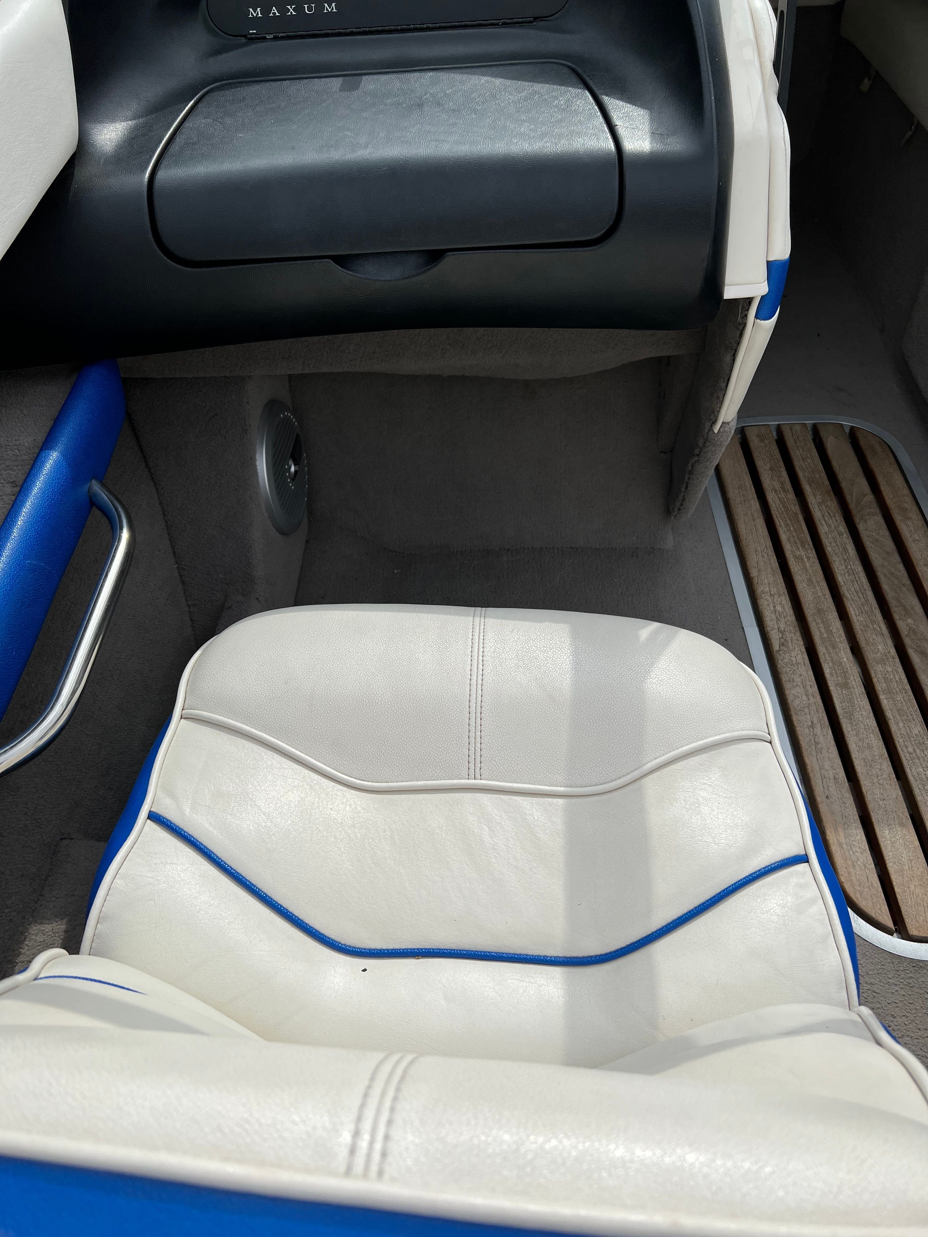 Interior of a 1991 Maxum 1800 SR with white and blue seating and wooden flooring.