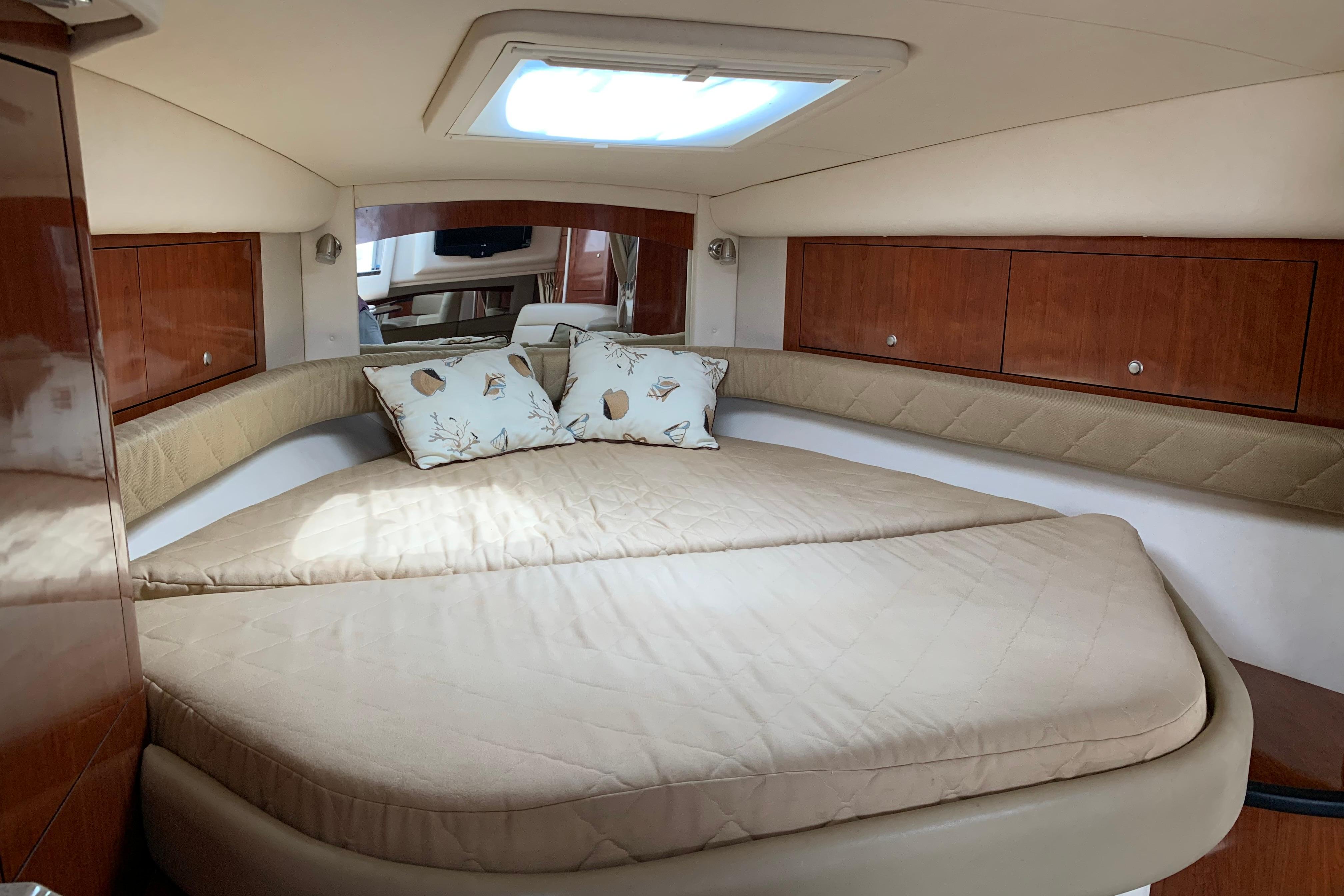 Luxurious cabin interior of 2007 Sea Ray 340 Sundancer yacht with cozy bedding.