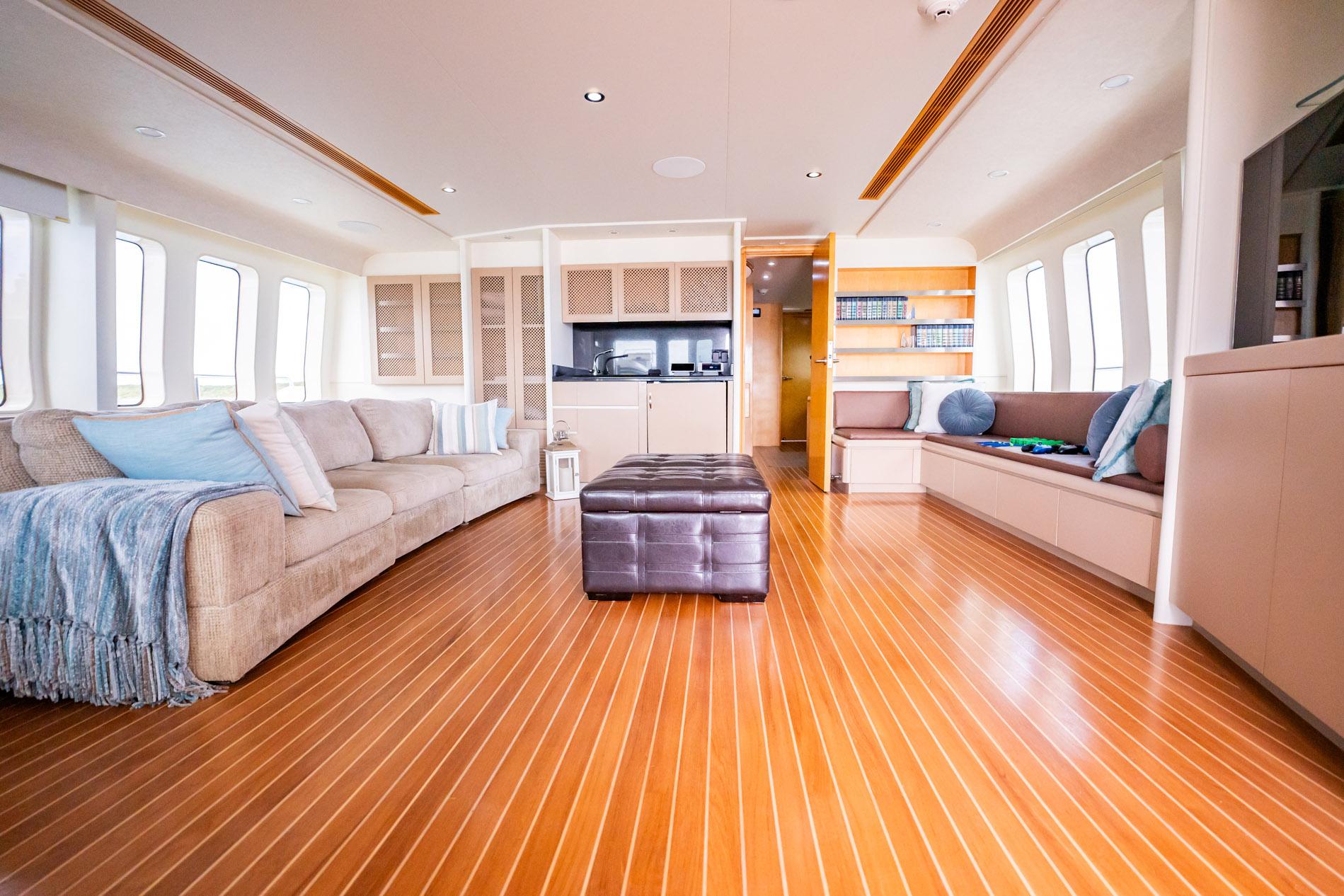 Luxurious interior of 1996 Cheoy Lee 145 Global Series yacht with elegant seating and wooden flooring.