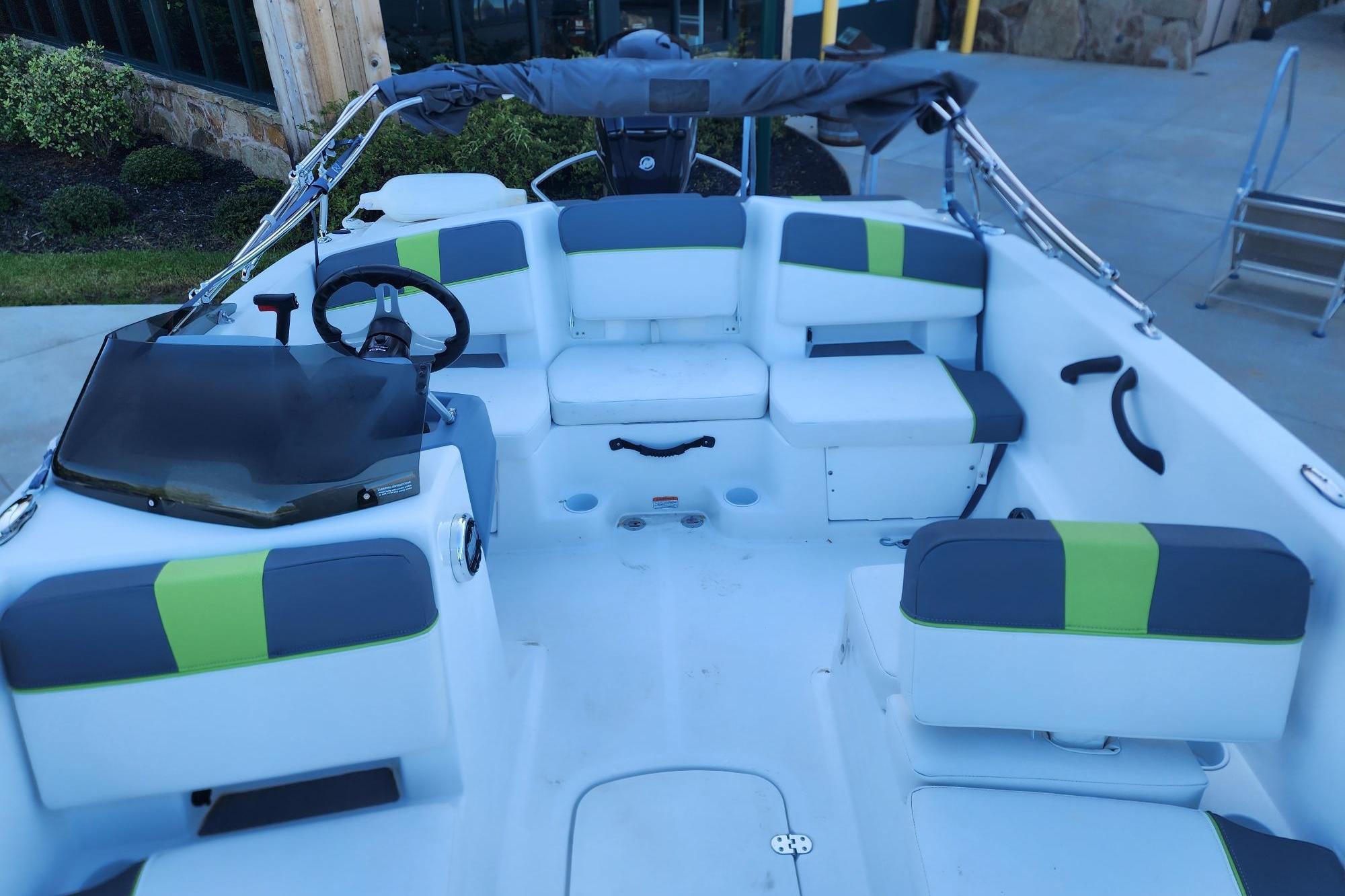 2023 Tahoe T18 boat interior with modern seating and steering wheel, docked outdoors.