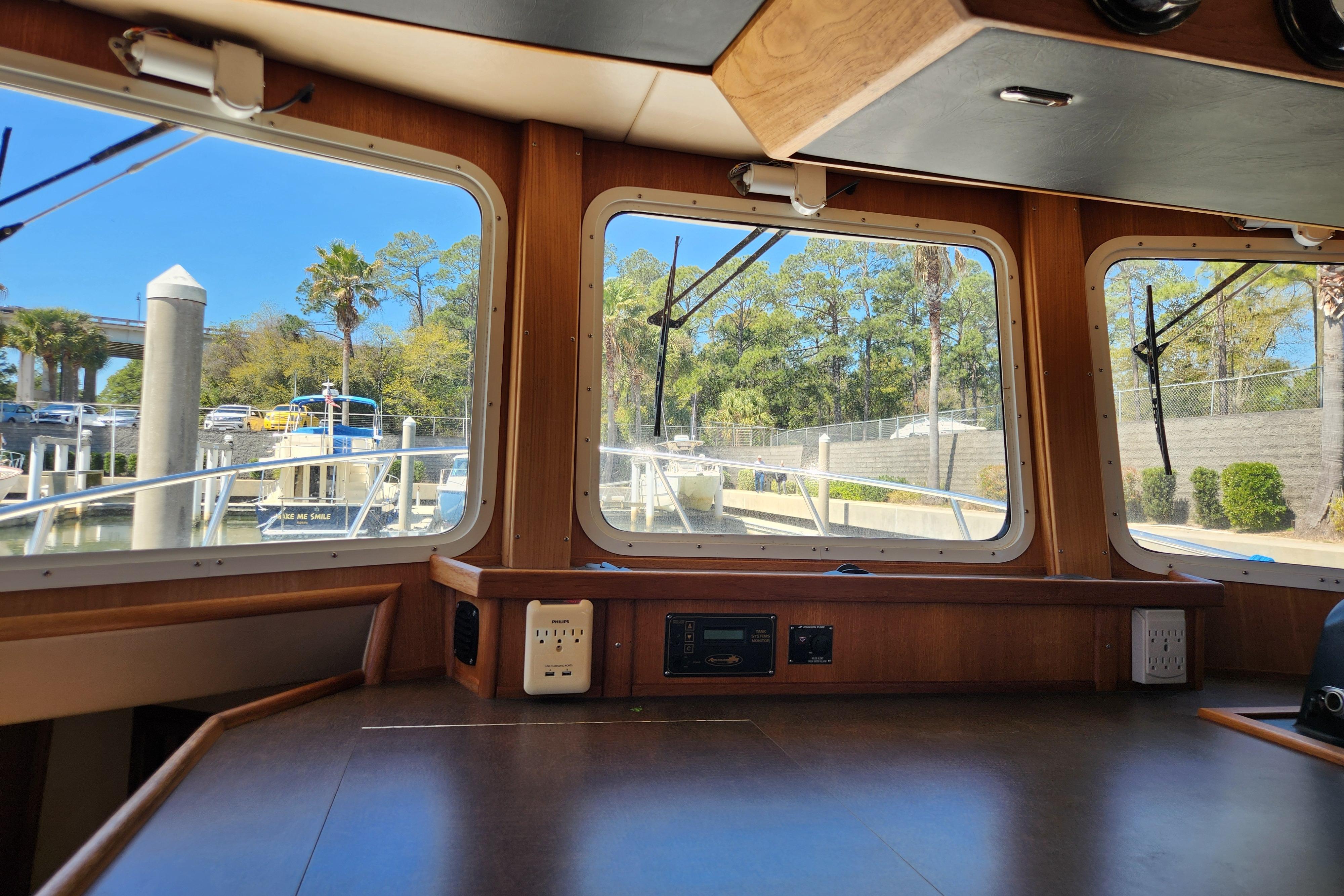 Interior view of a 2006 American Tug AT, showcasing large windows and a wooden dashboard.