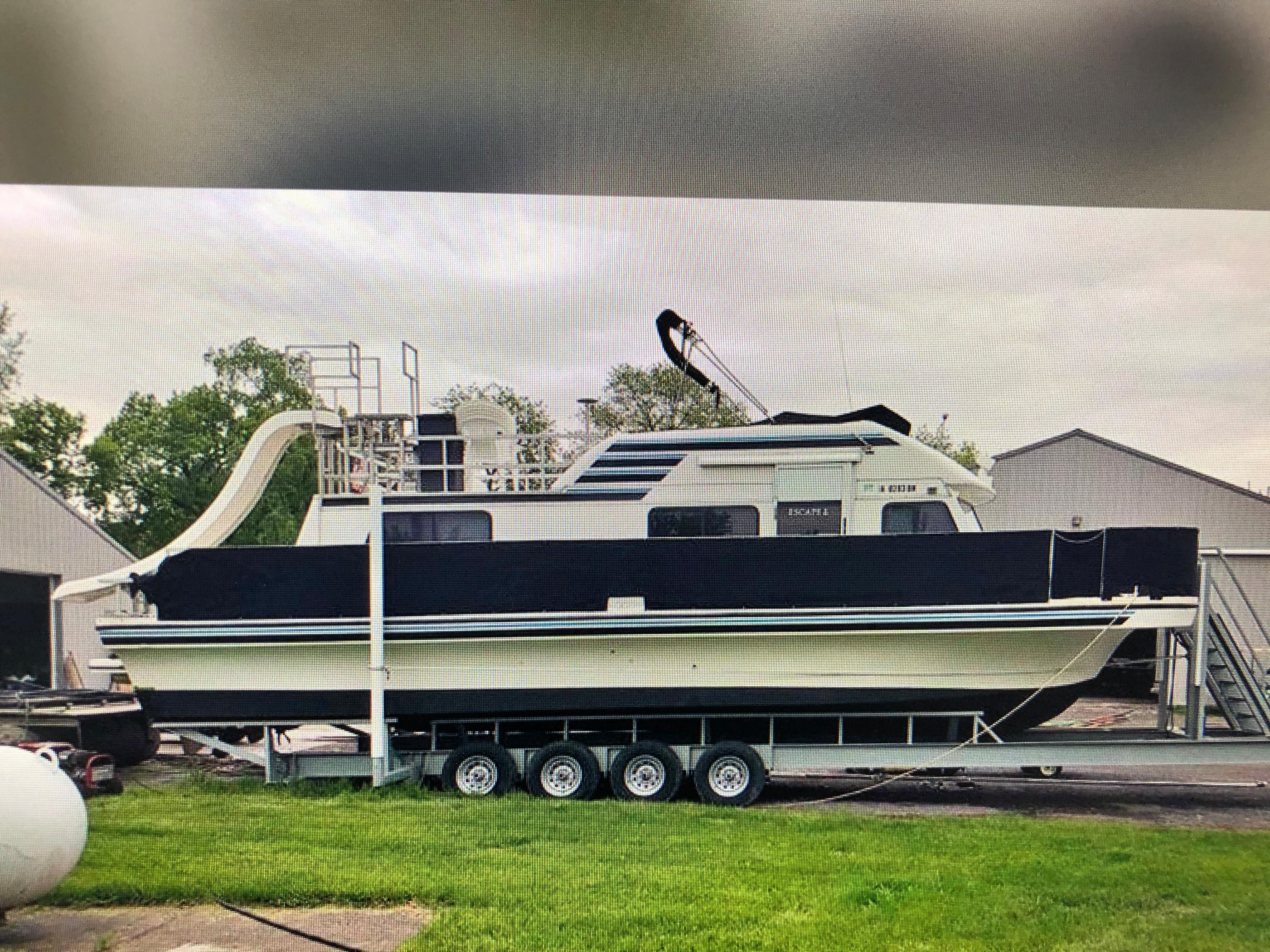 A 1993 Gibson Sport Series boat on a trailer beside a building.