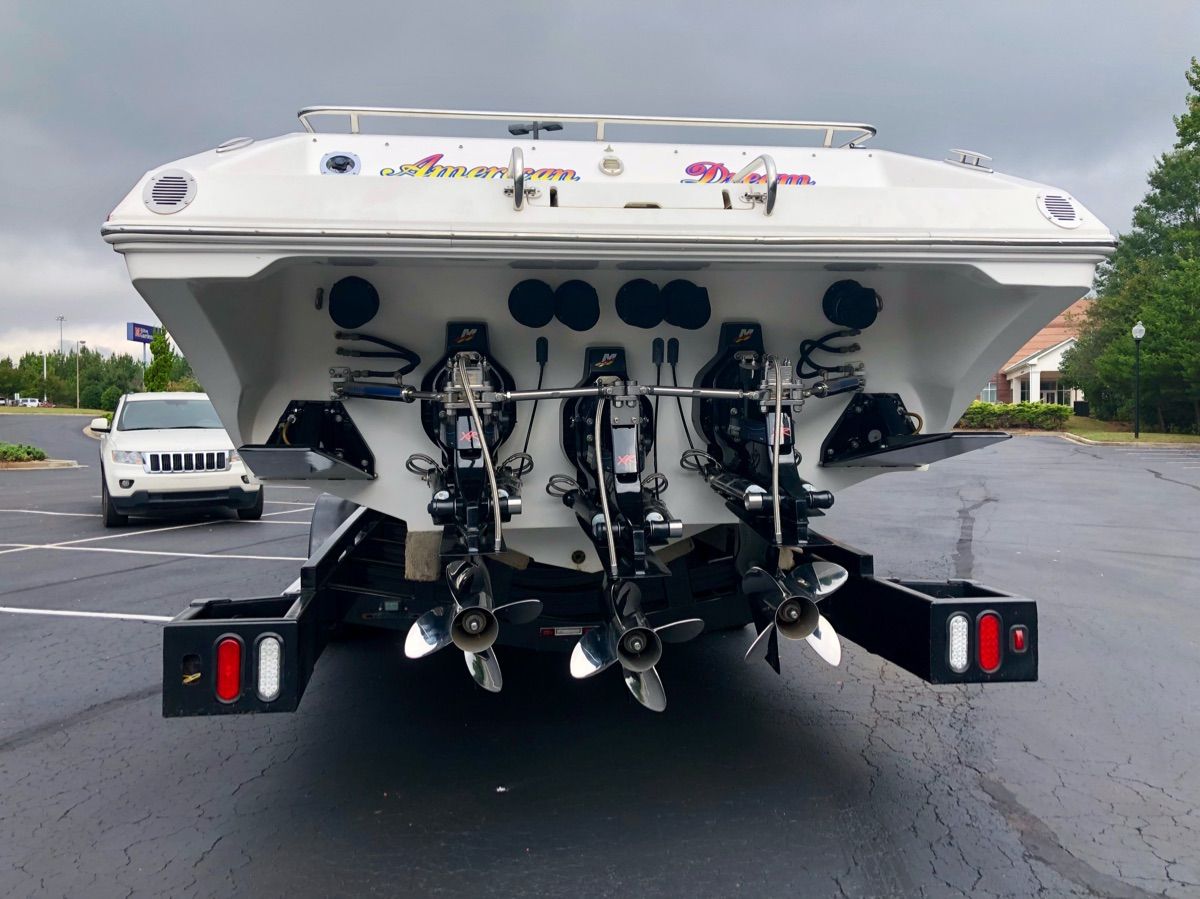Rear view of a 2005 Fountain 47 Lightning with three outboard engines on a trailer.