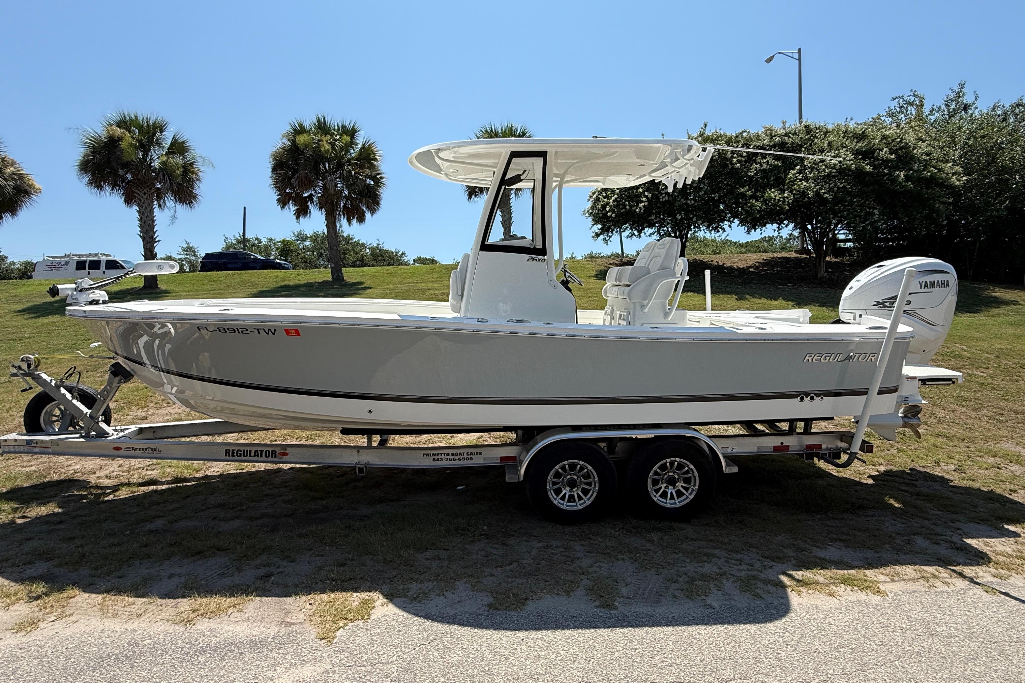 2023 Regulator 26XO boat on trailer, parked outdoors with palm trees in background.