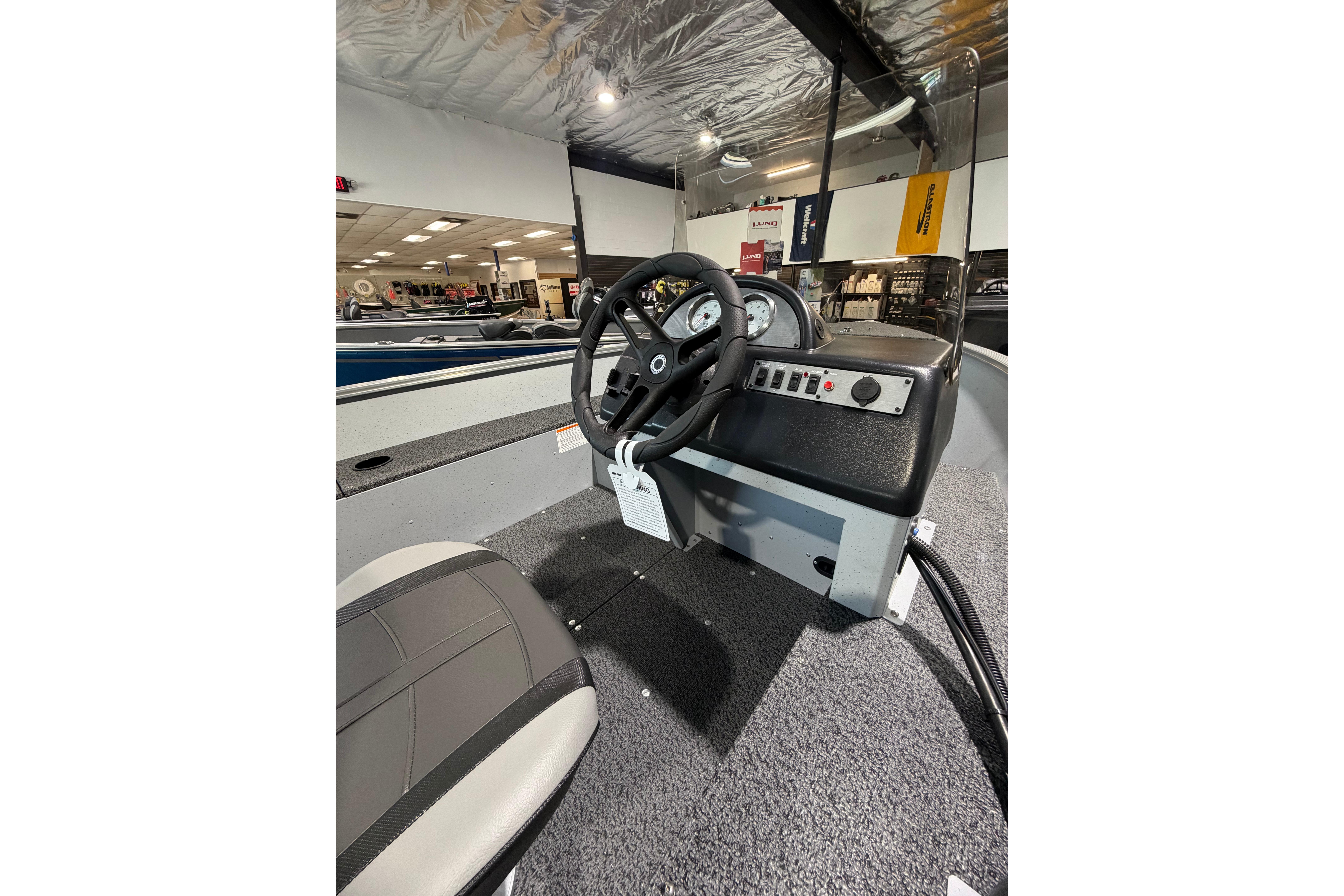 Interior view of 2027 Lund 1600 Fury SS boat, showcasing steering console and seating.