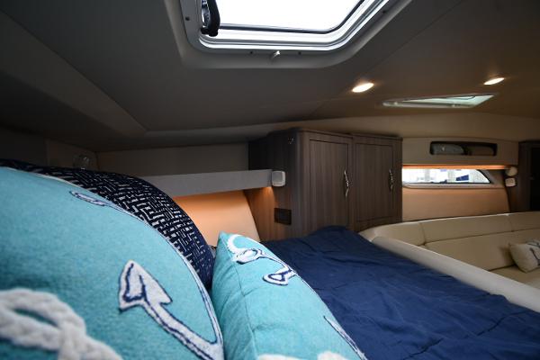 Interior cabin of 2021 Regal 35 Sport Coupe with nautical-themed bedding.