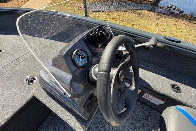 2026 Ranger VS1665SC boat dashboard with steering wheel and gauge, near a lake.